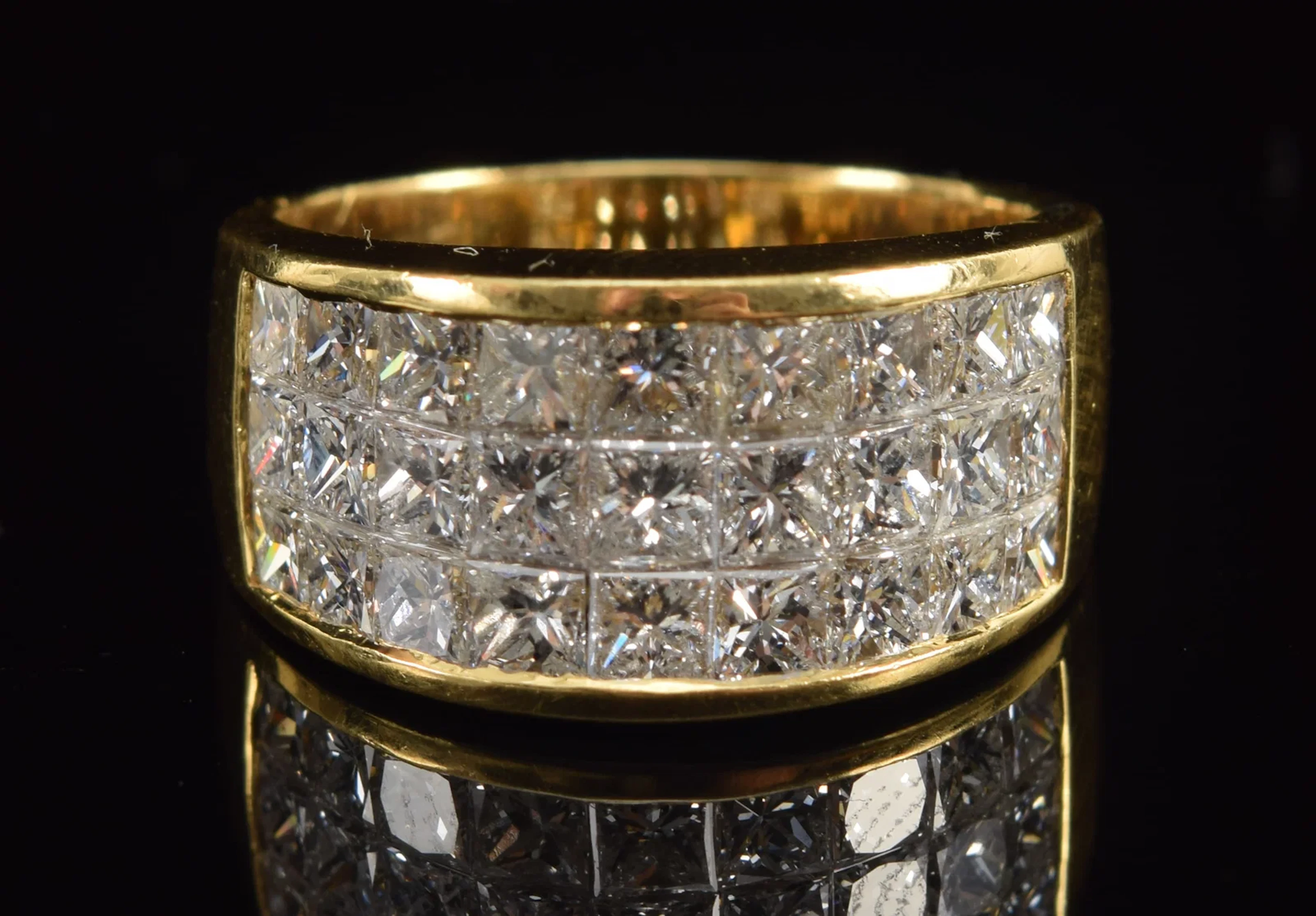 18K gold diamond ring. 3 channels of slightly graduated square cut