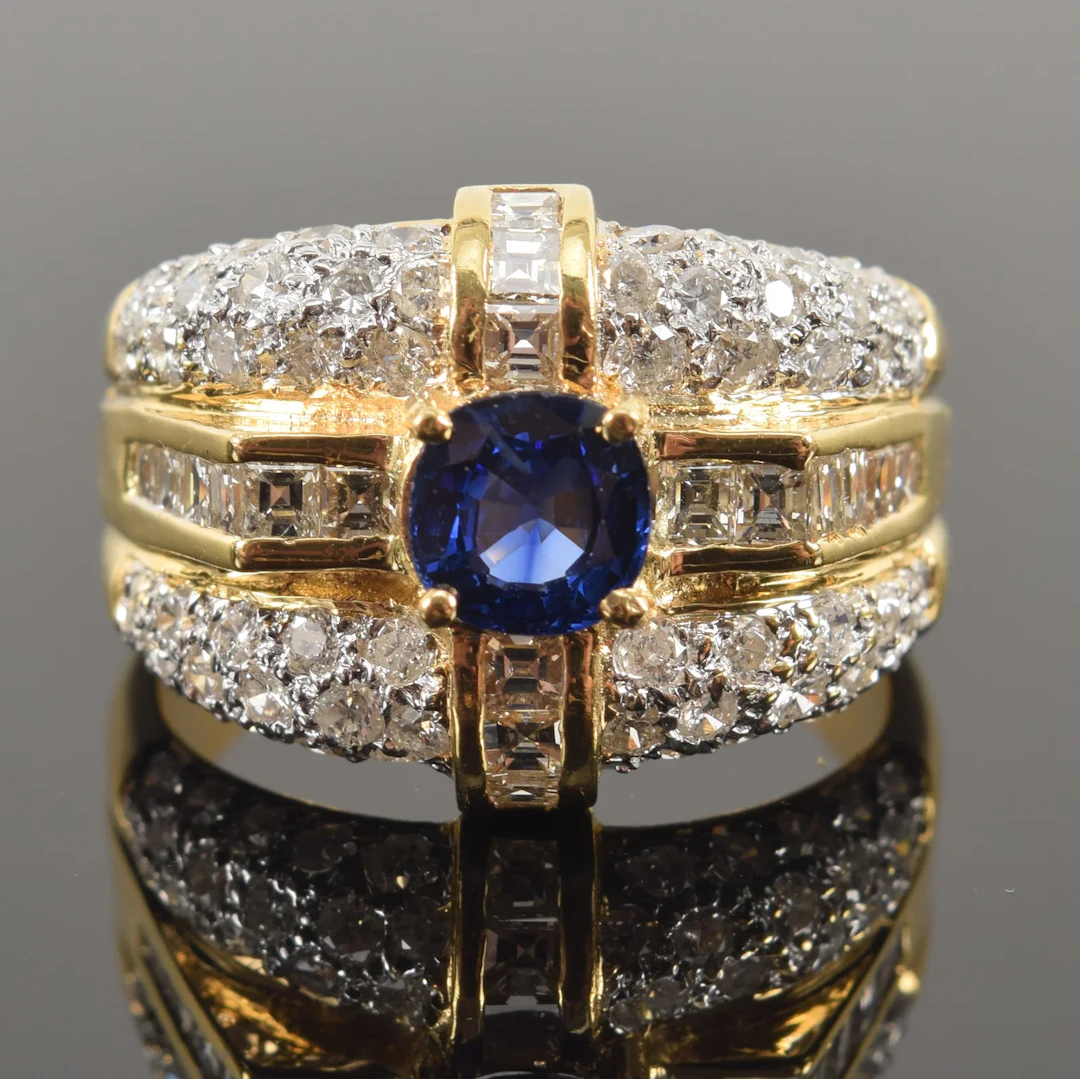 18K gold sapphire and diamond ring. Central round cut sapphire (about