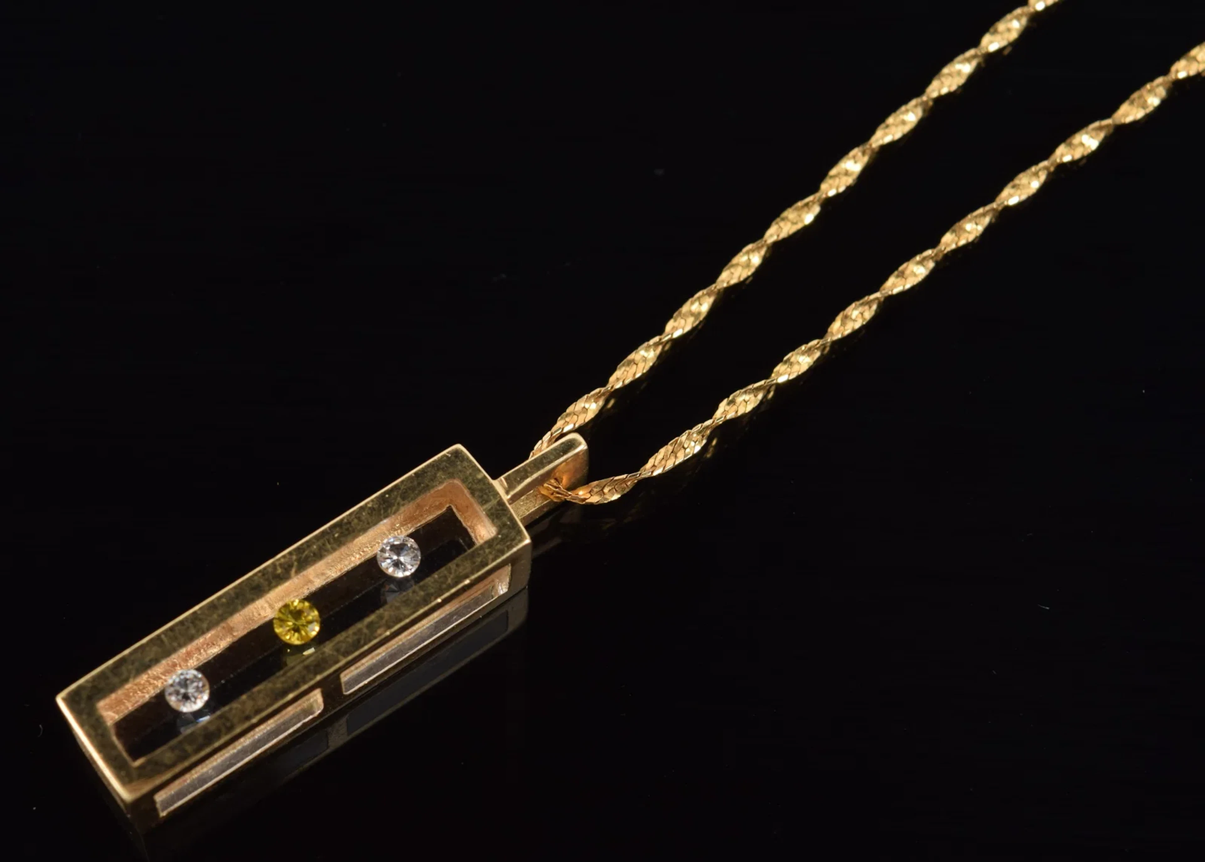 14K gold diamond set cylinder pendant necklace. Pendant set with "floating"