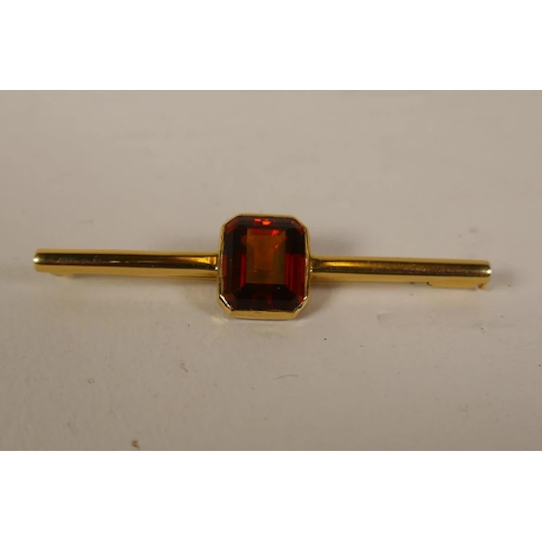 18ct gold bar brooch set with an orange stone, probably garn...