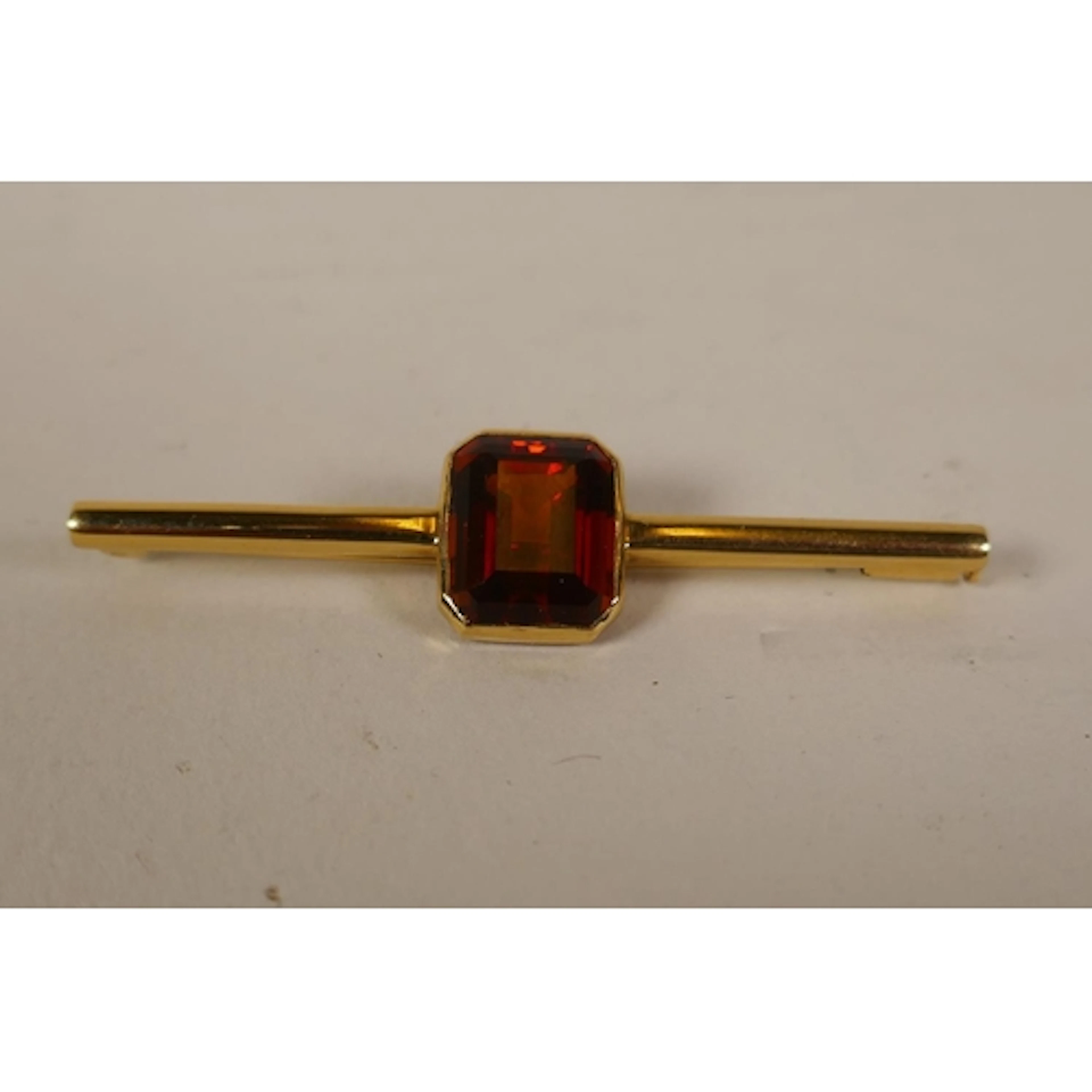 18ct gold bar brooch set with an orange stone, probably garn...