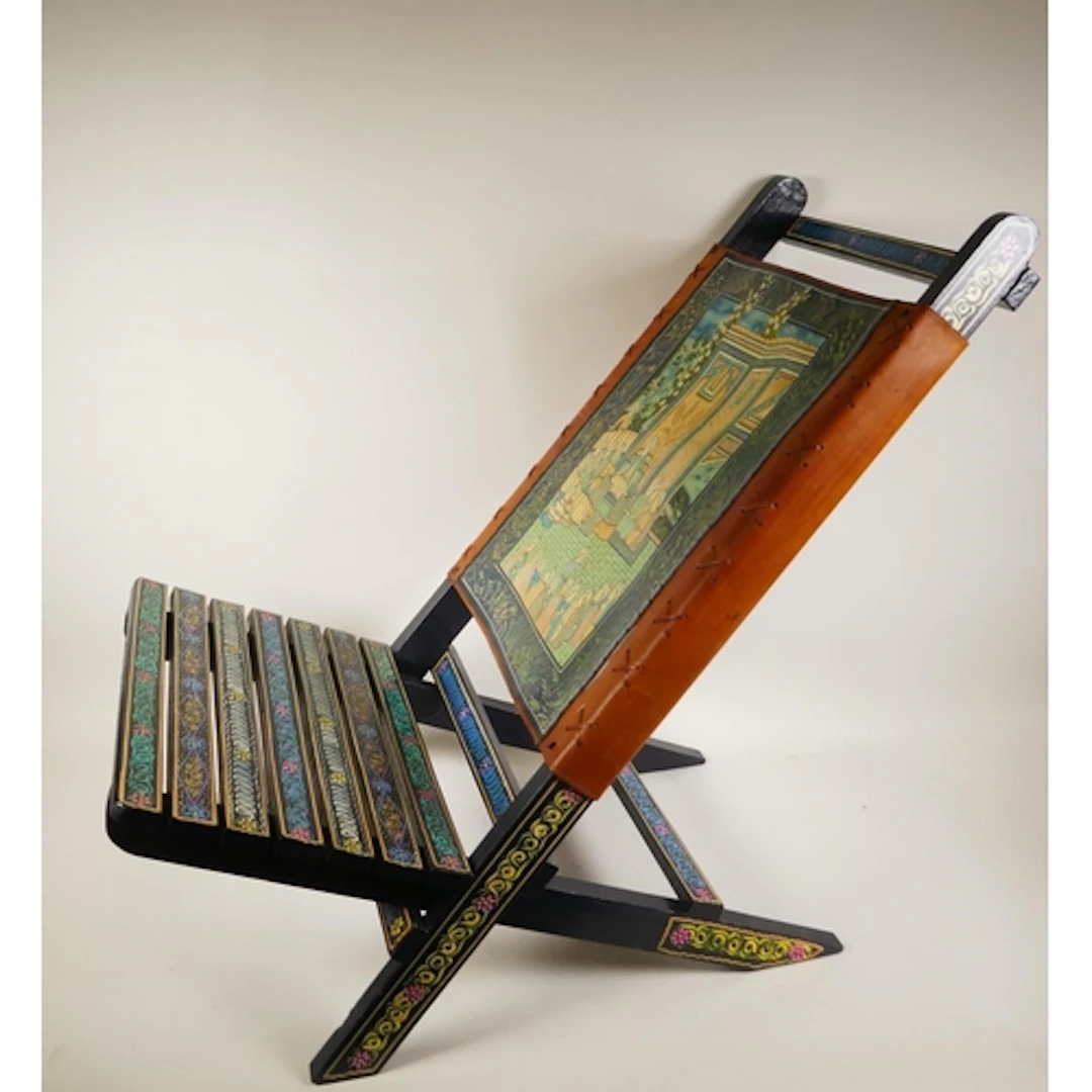 An Indian painted wood interlocking two piece low chair with...