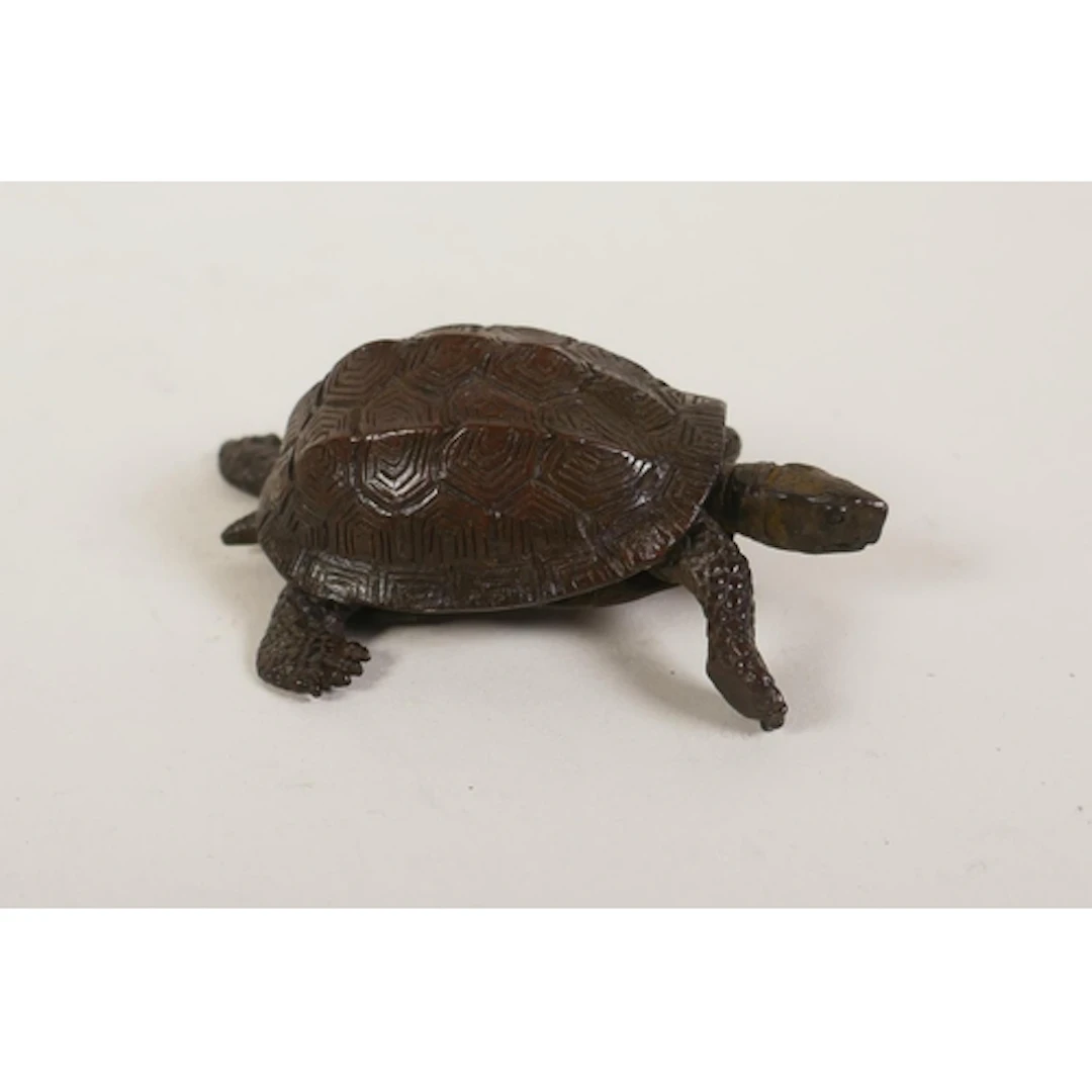 A miniature bronzed metal tortoise with articulated limbs, i...