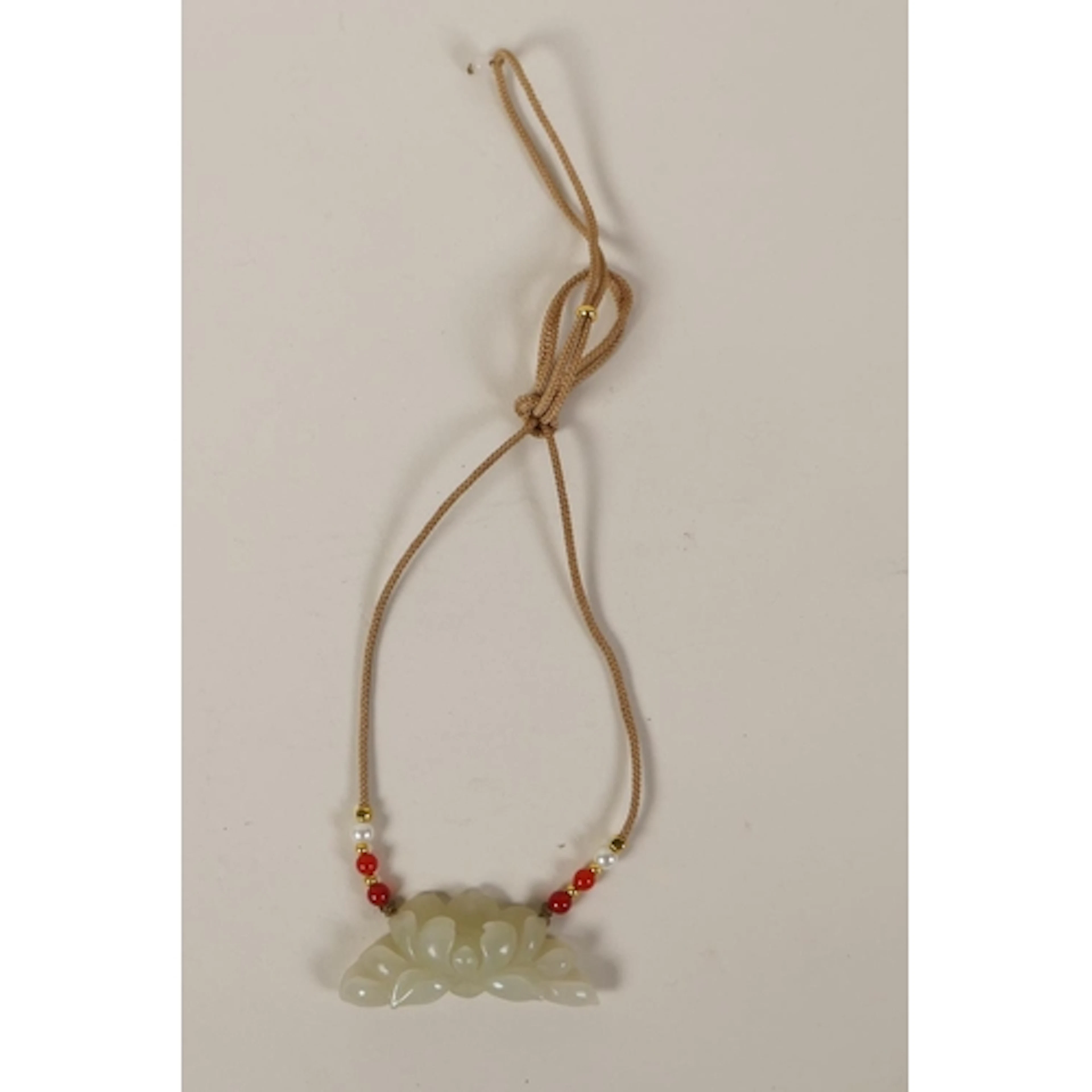 A carved jade lotus flower pendant necklace, 6cm wide