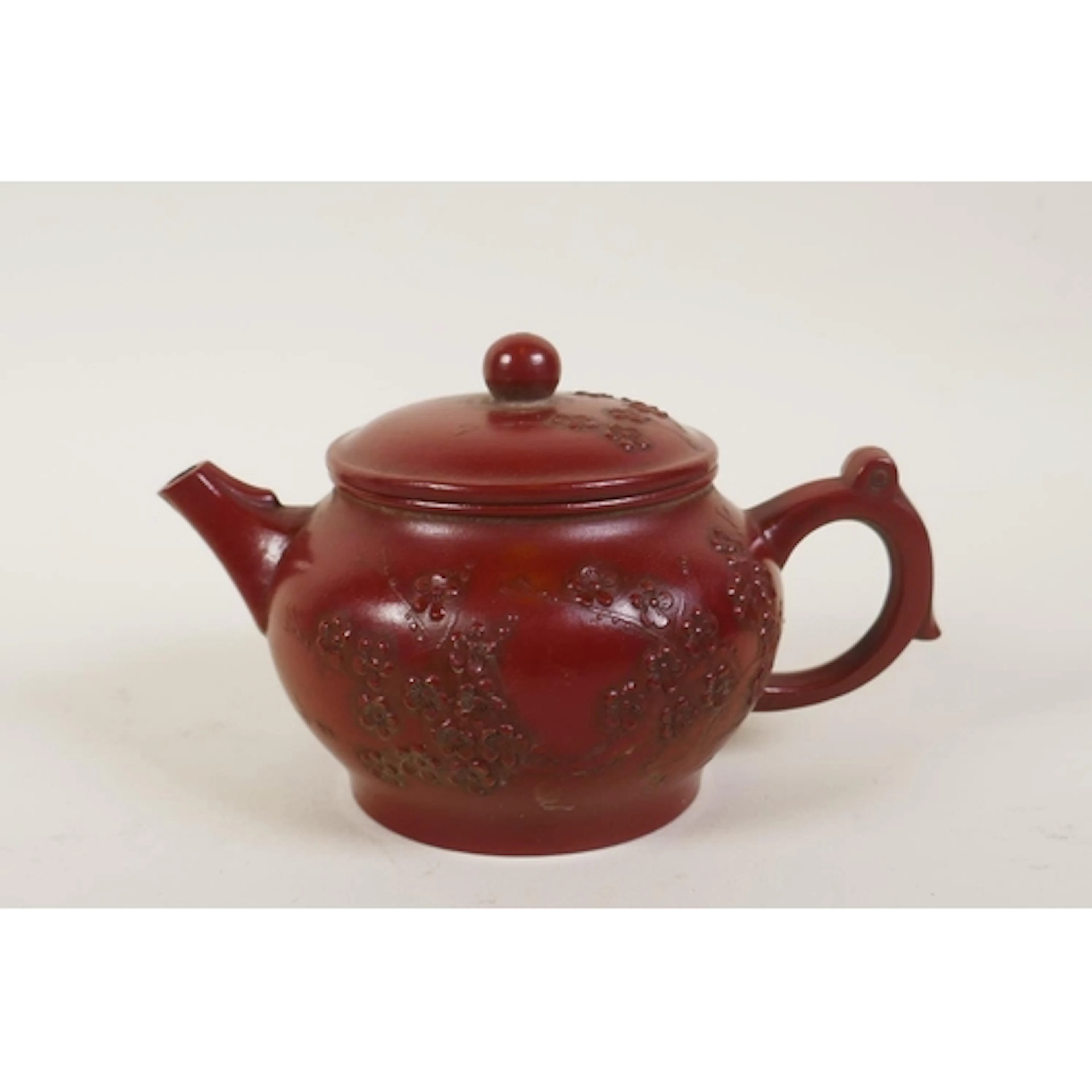 A Chinese YiXing teapot with raised prunus blossom decoratio...