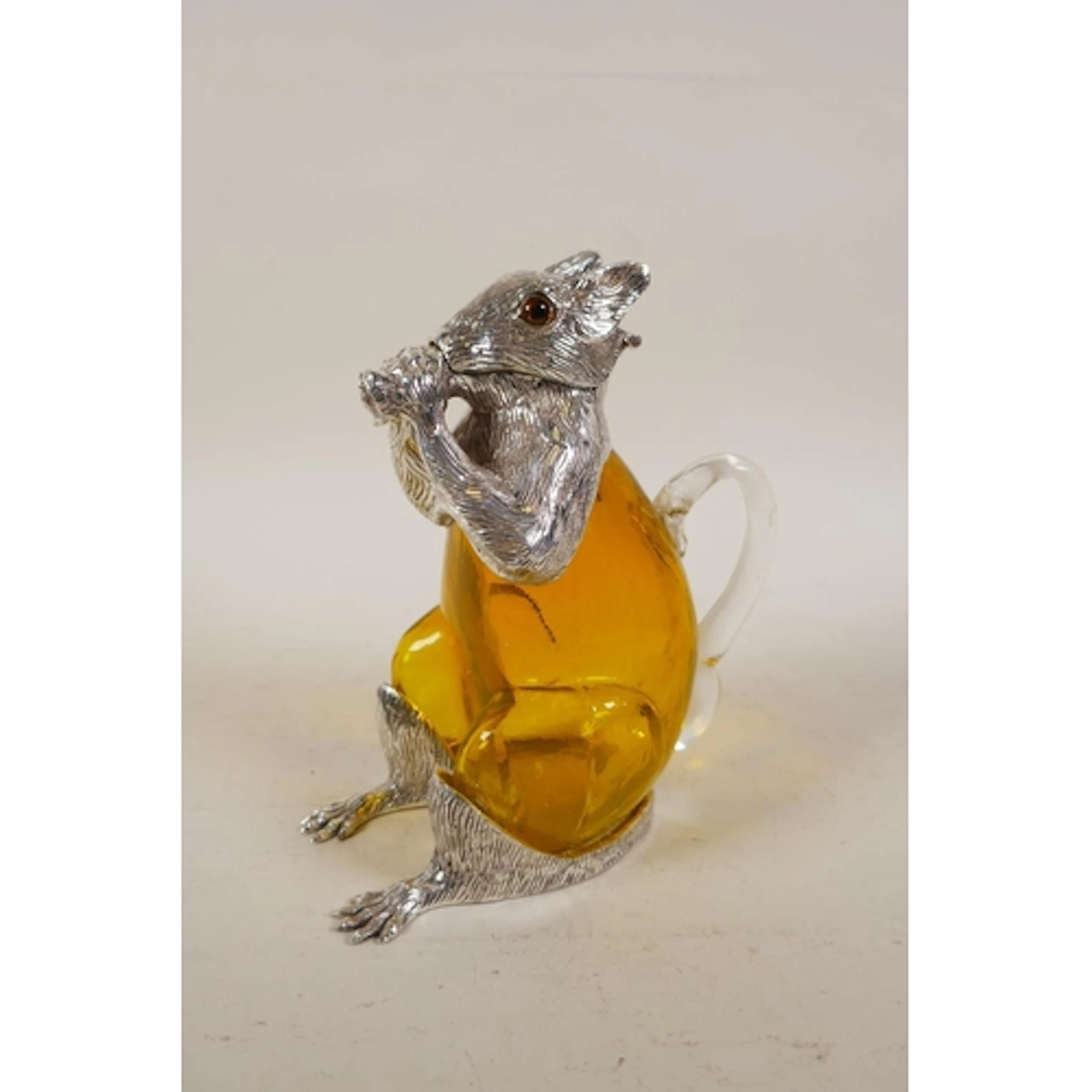 A silver plated and yellow glass claret jug in the form of a...