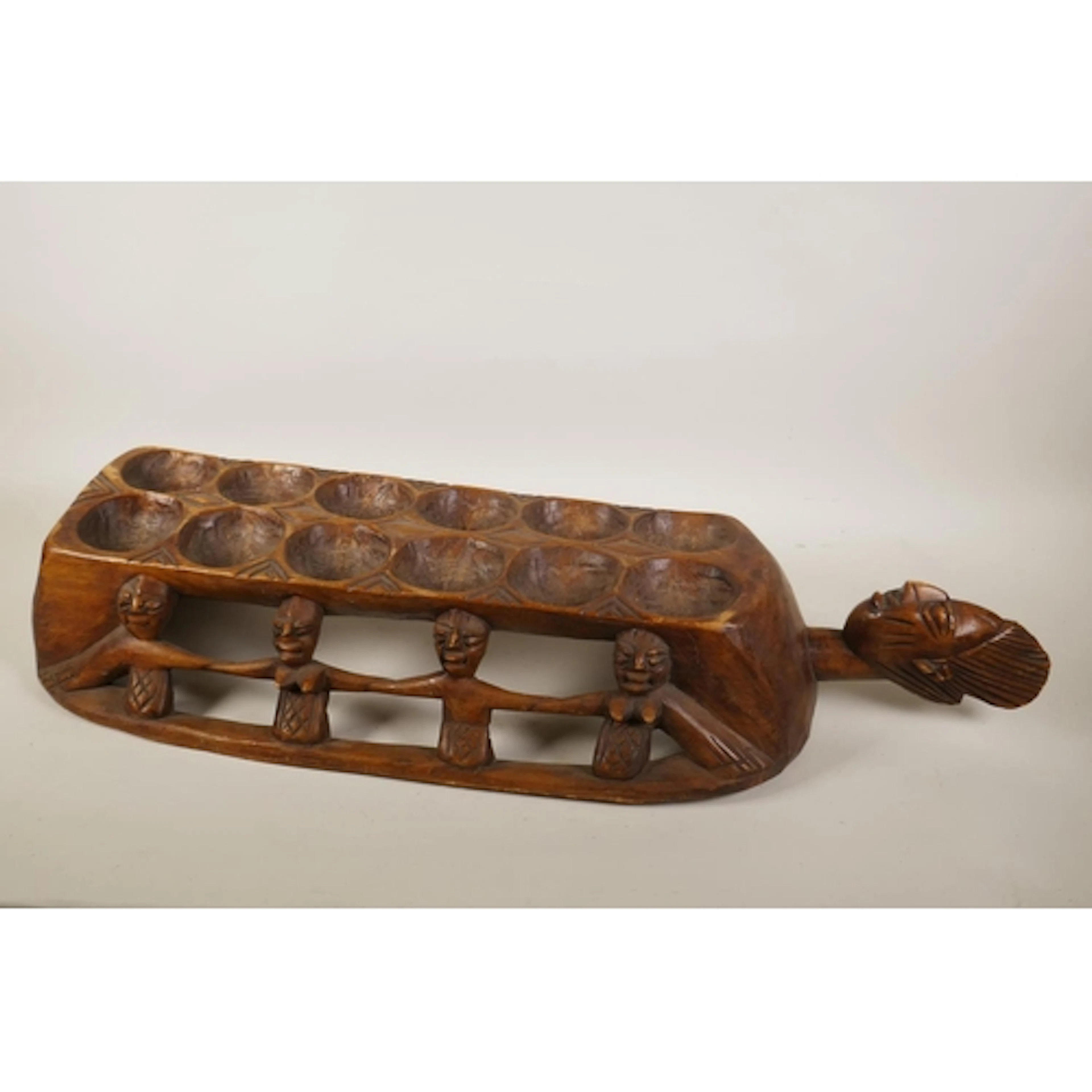 An African hand carved wood mancala board, featuring figures...