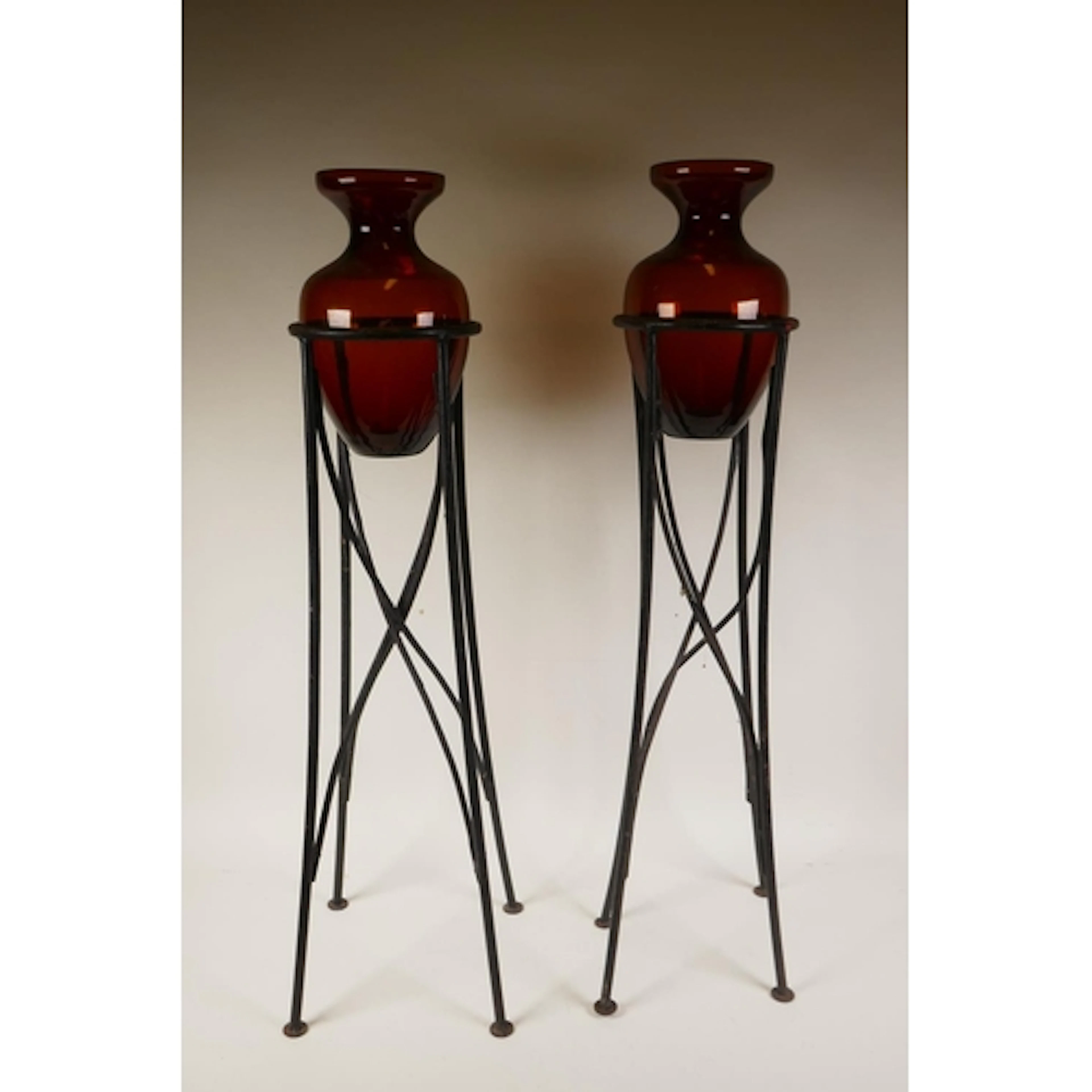 A pair of wrought metal and amber glass floor vases, 80cm hi...
