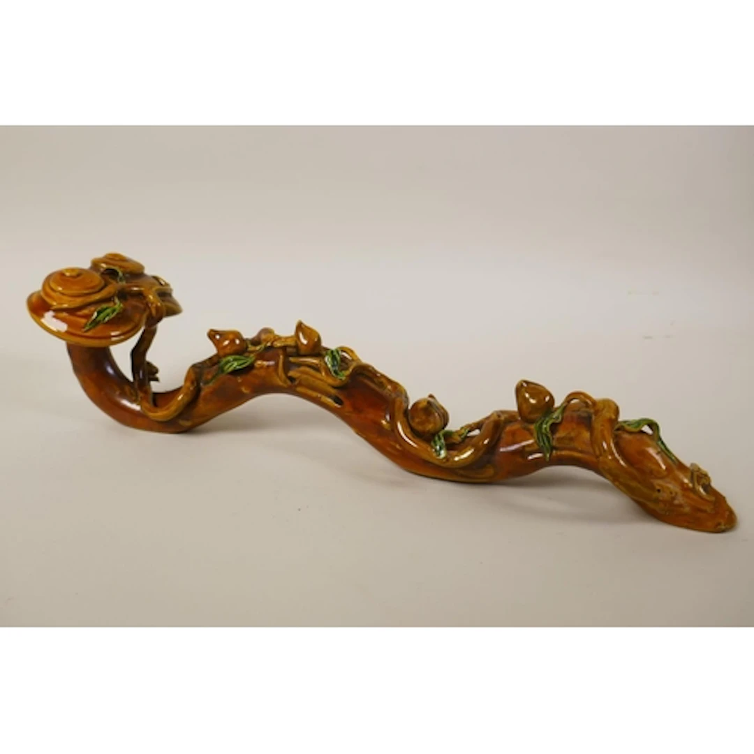 A Chinese sancai glazed porcelain ruyi with peach tree decor...