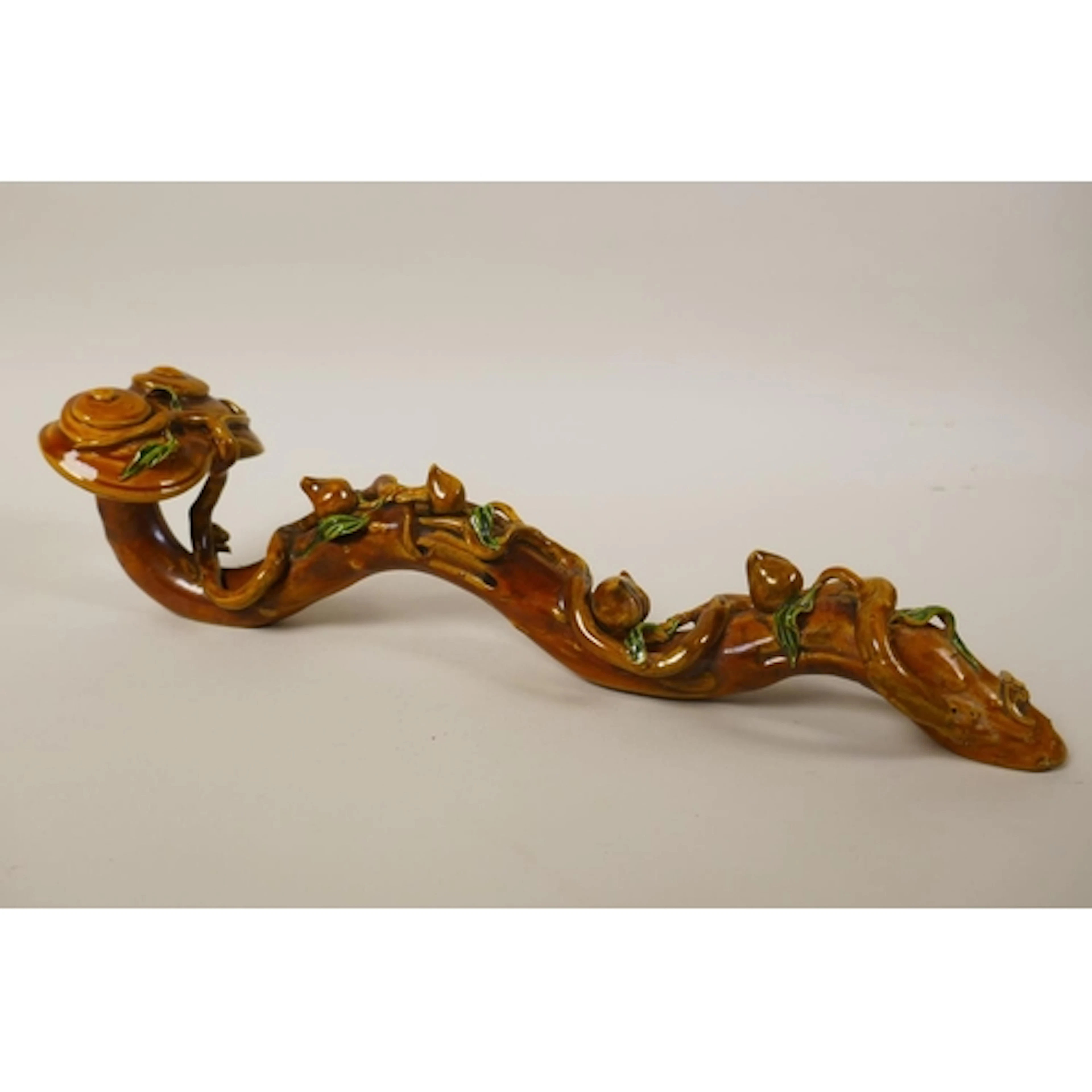 A Chinese sancai glazed porcelain ruyi with peach tree decor...
