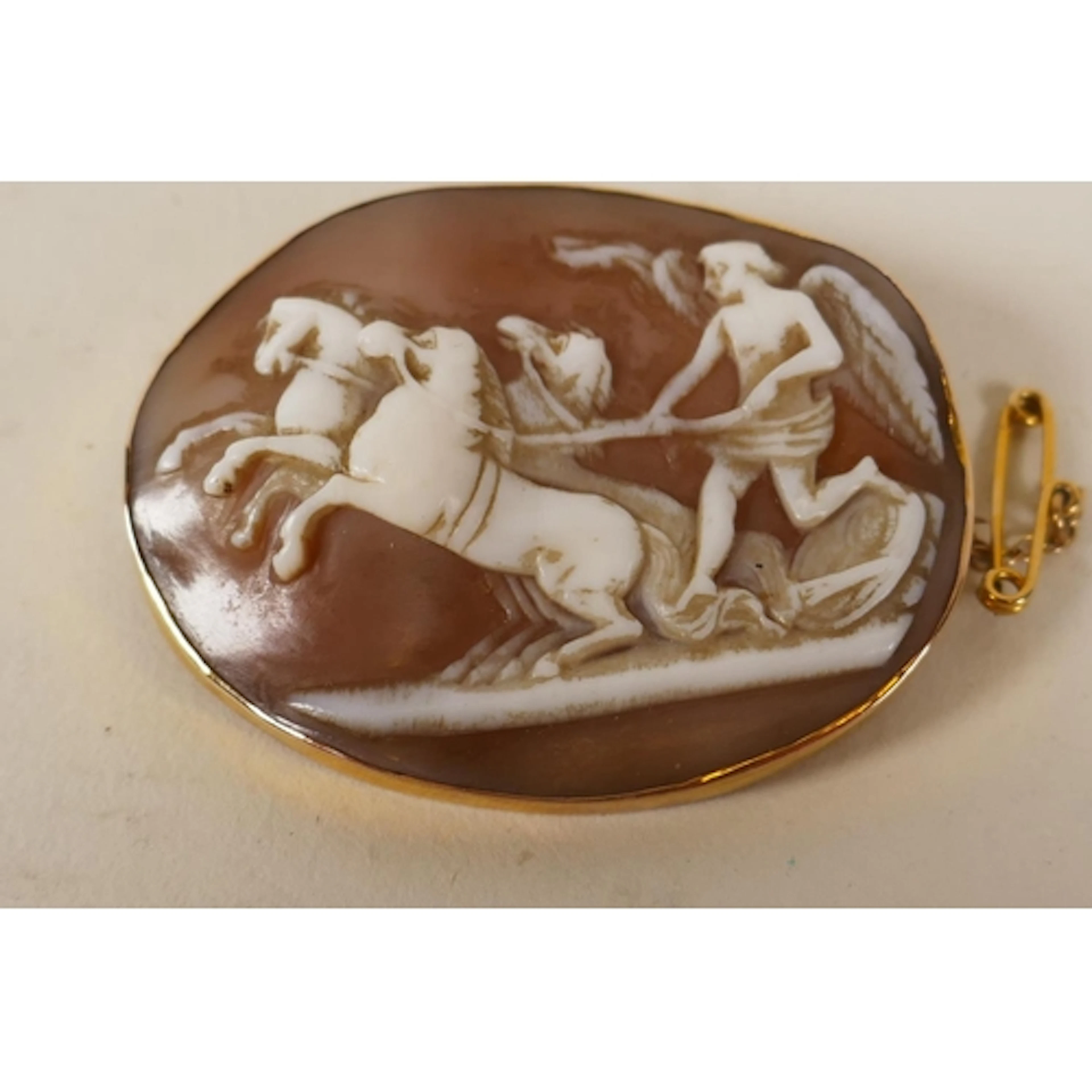 An antique 9ct gold cameo brooch, carved with a scene ...