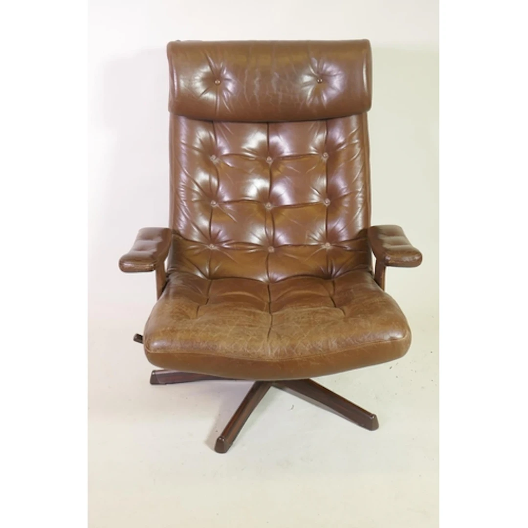 A mid century revolving and tilting easy chair with button b...