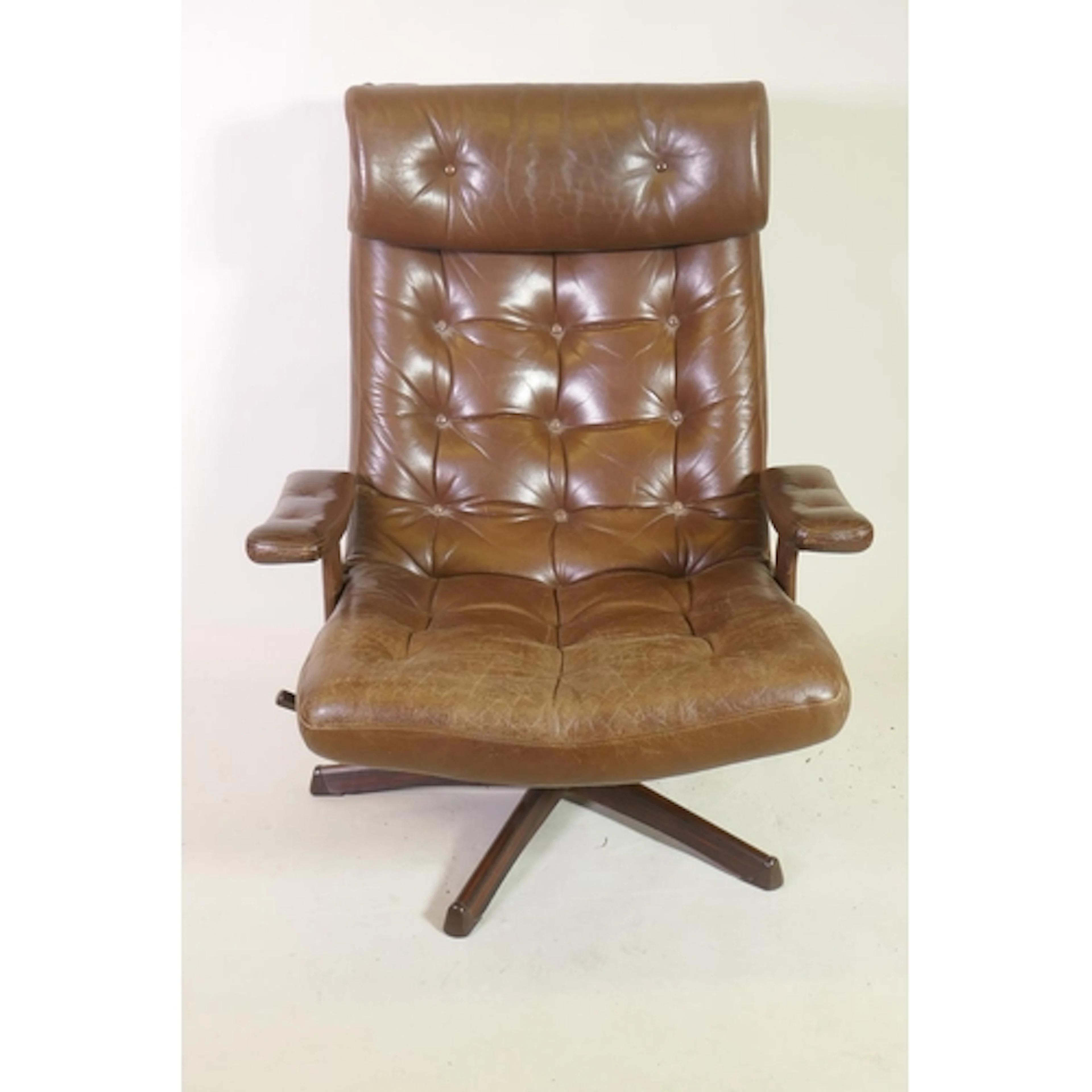 A mid century revolving and tilting easy chair with button b...
