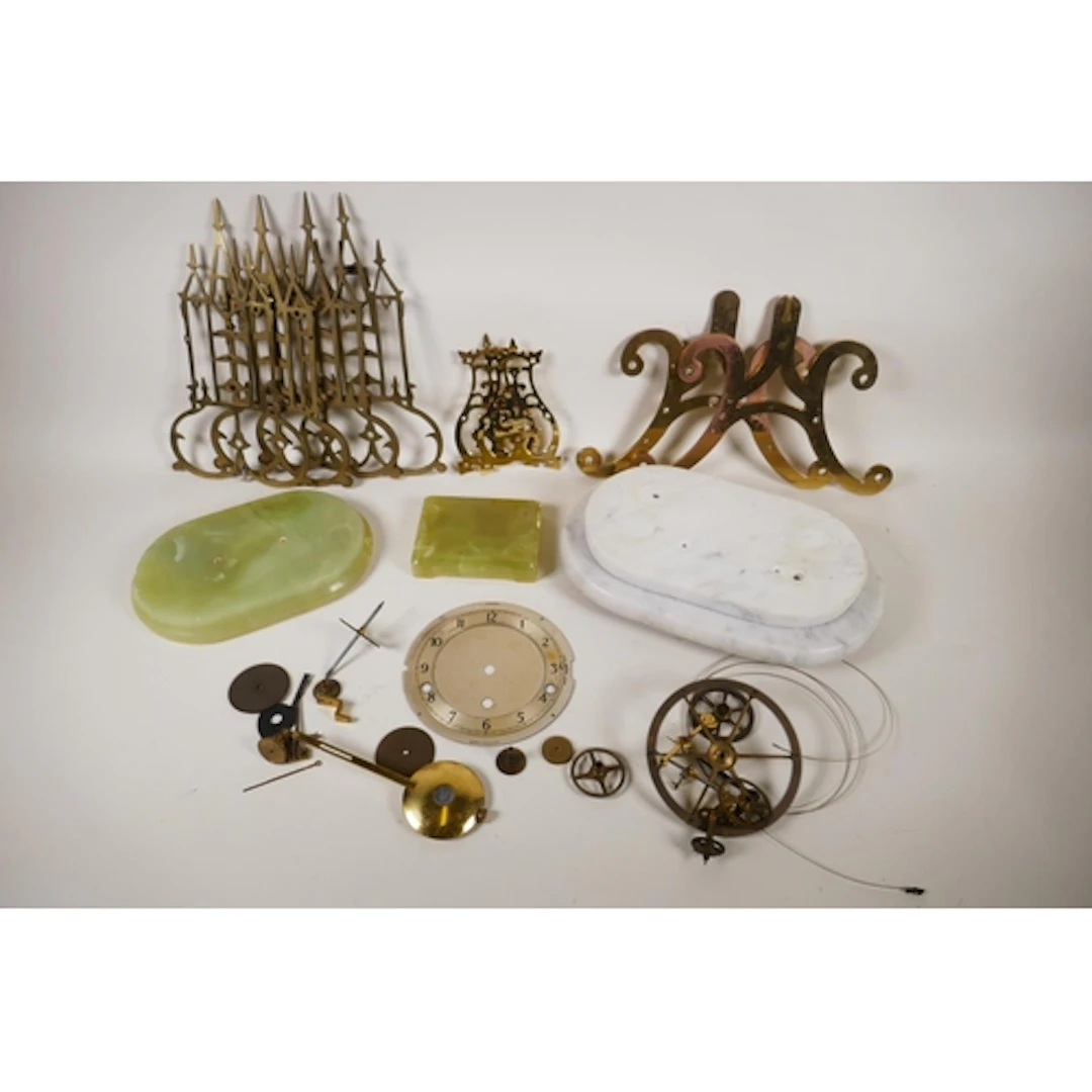 A collection of disassembled brass skeleton clock parts and ...
