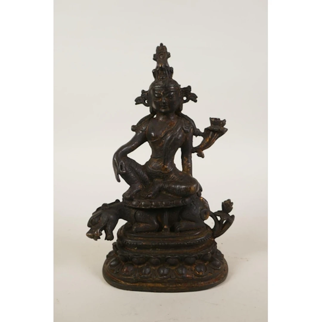 A Tibetan bronze tara seated on a kylin, 20cm high
