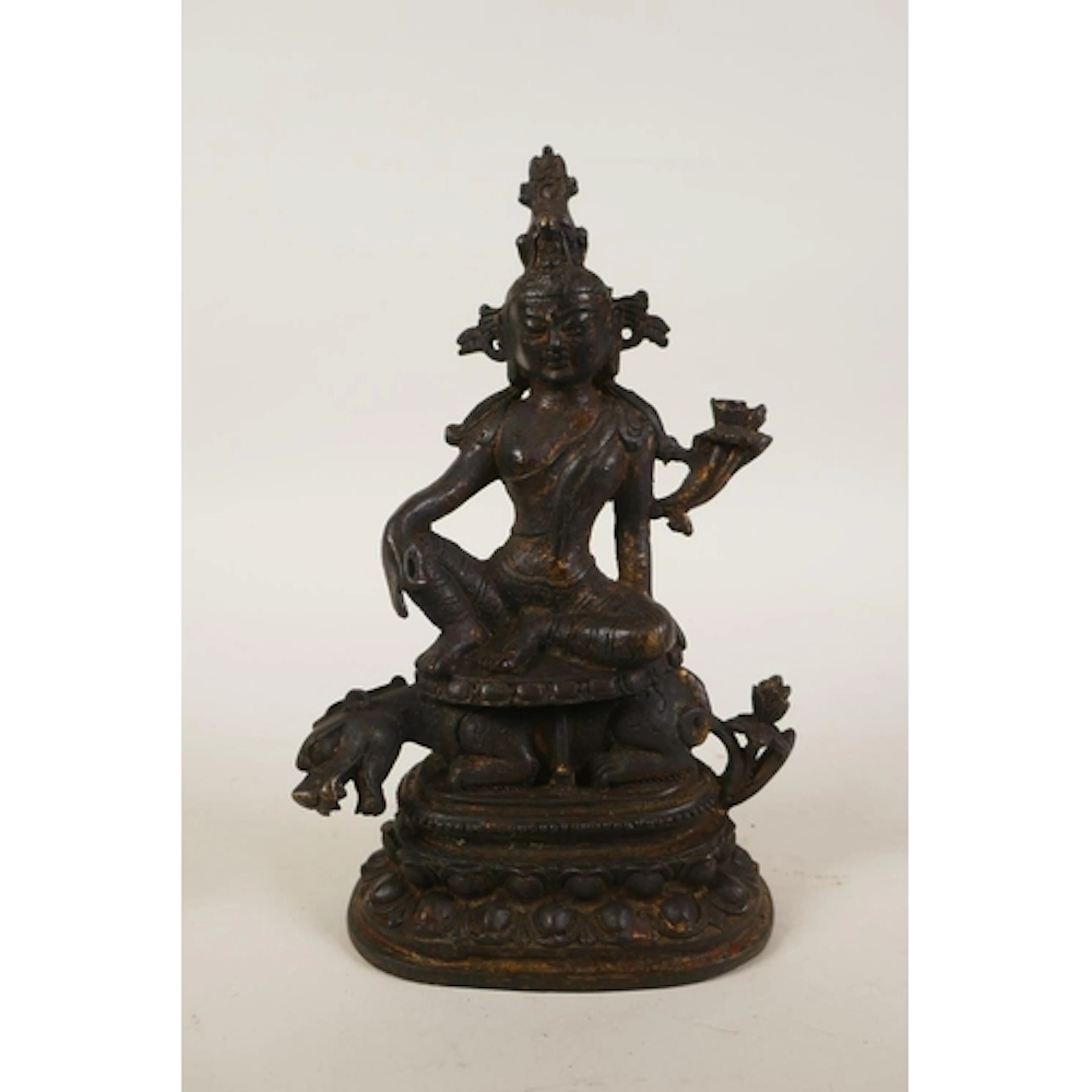 A Tibetan bronze tara seated on a kylin, 20cm high