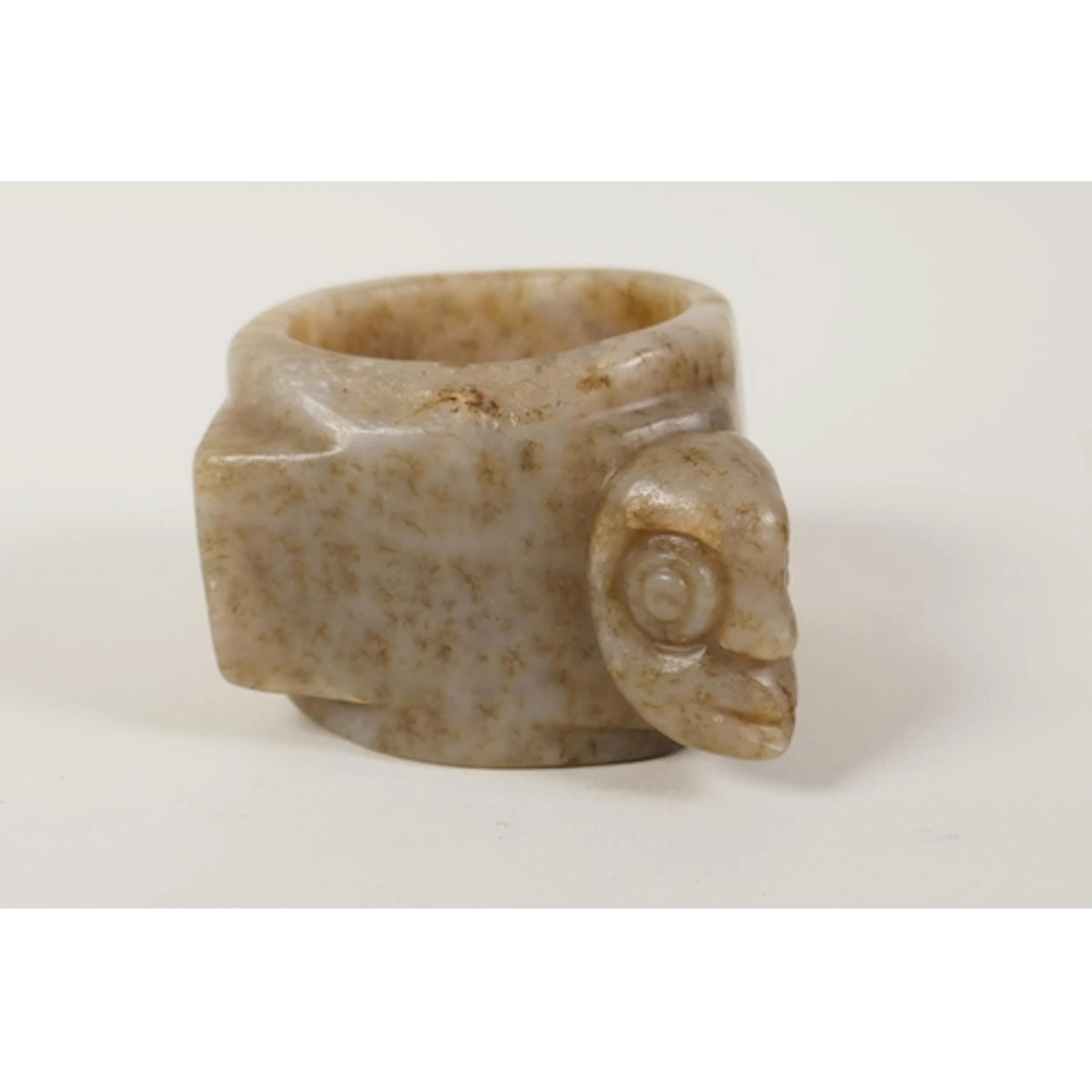 A Chinese nephrite jade bangle with carved mask decoration, ...