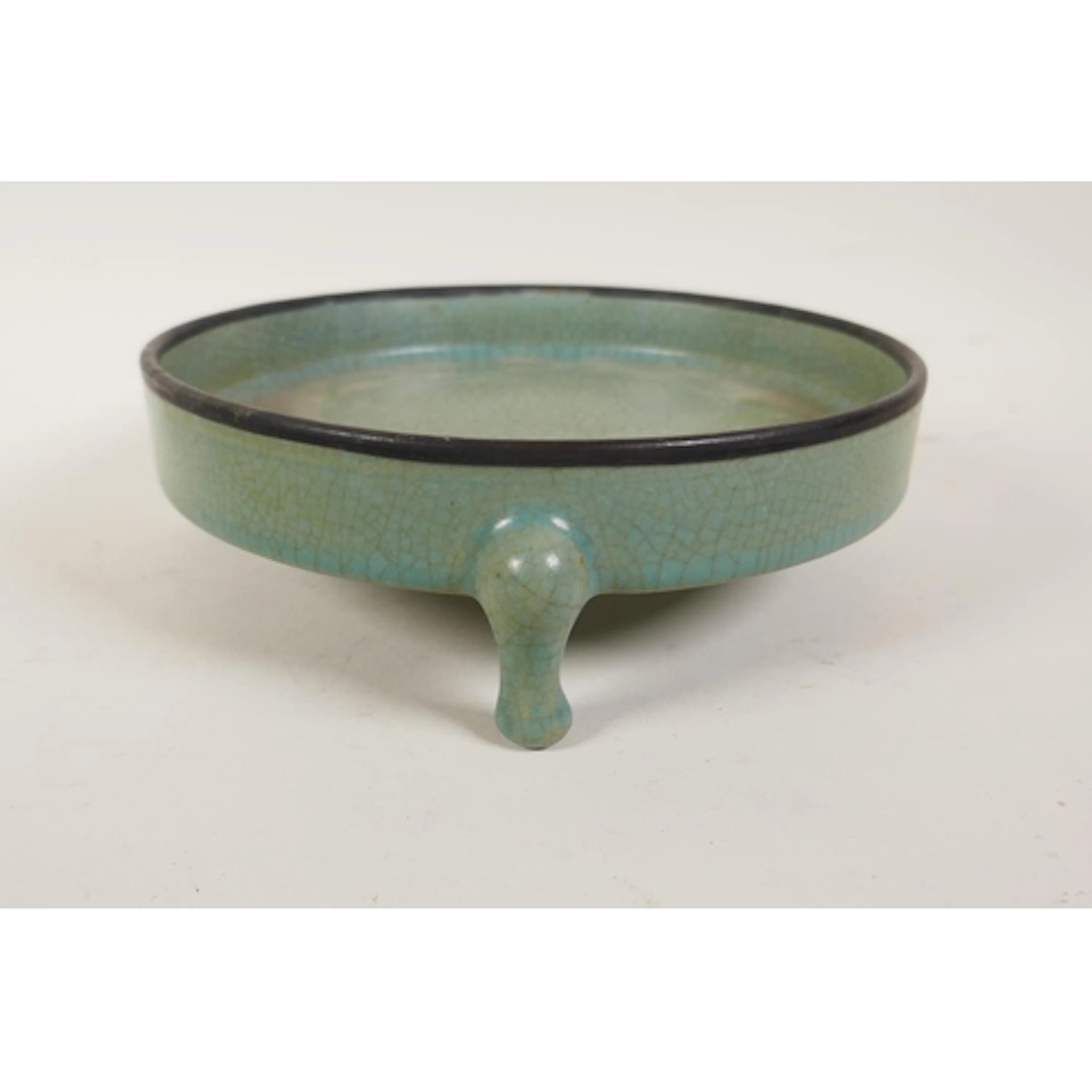 A Chinese celadon crackle glazed shall censer on tripod supp...
