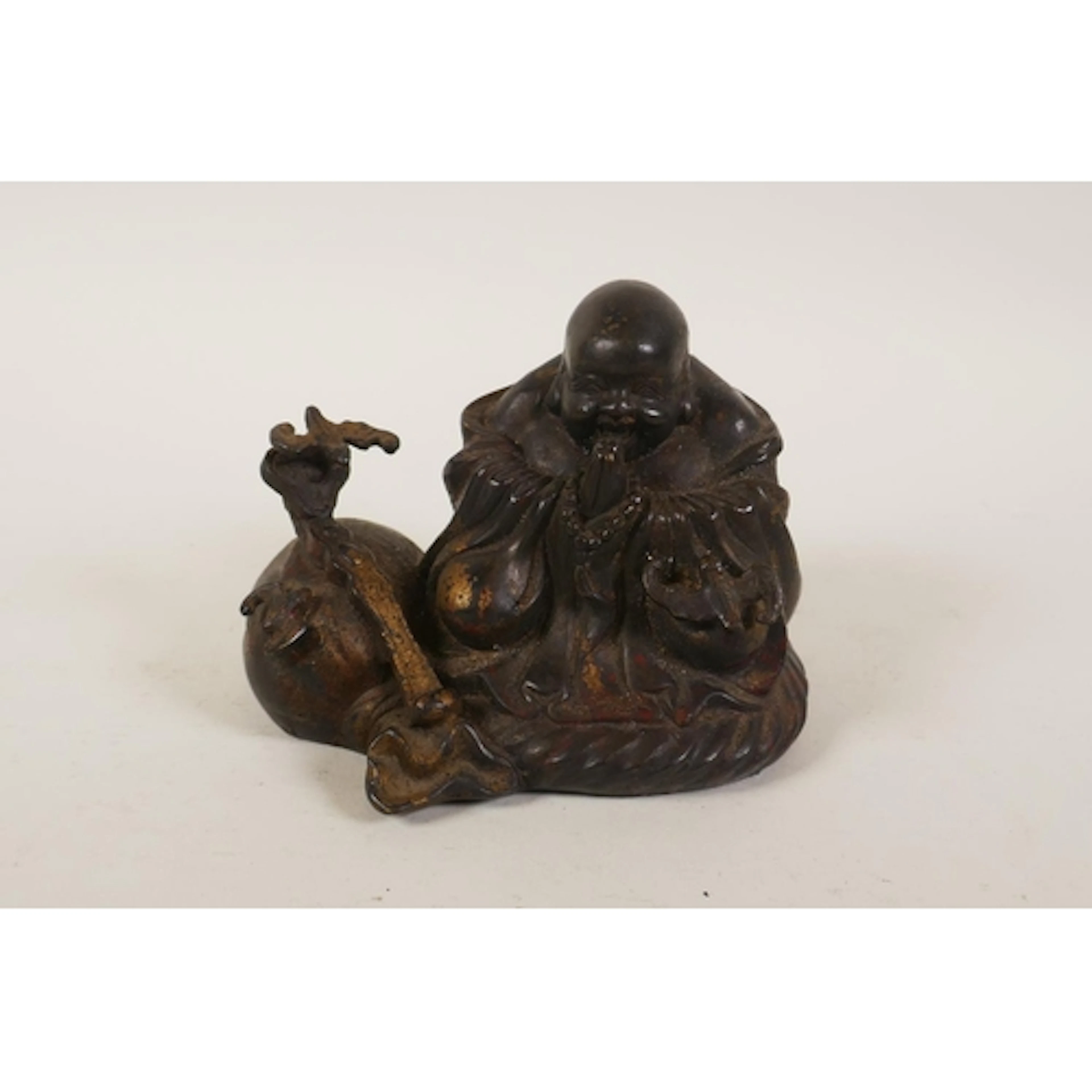 A Chinese filled bronze figure of a jolly Buddha seated in p...