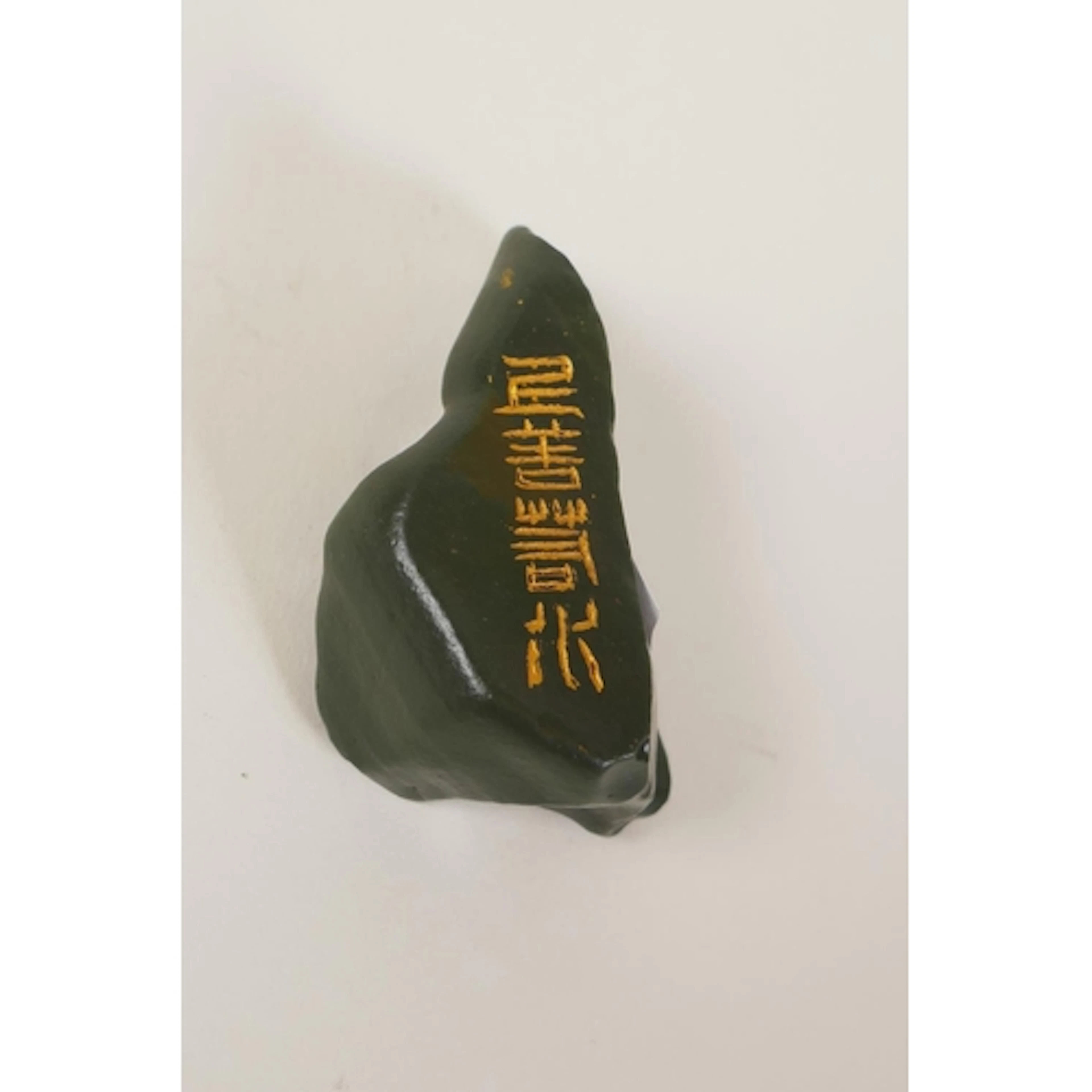 A Chinese green stone pendant with carved and gilt character...