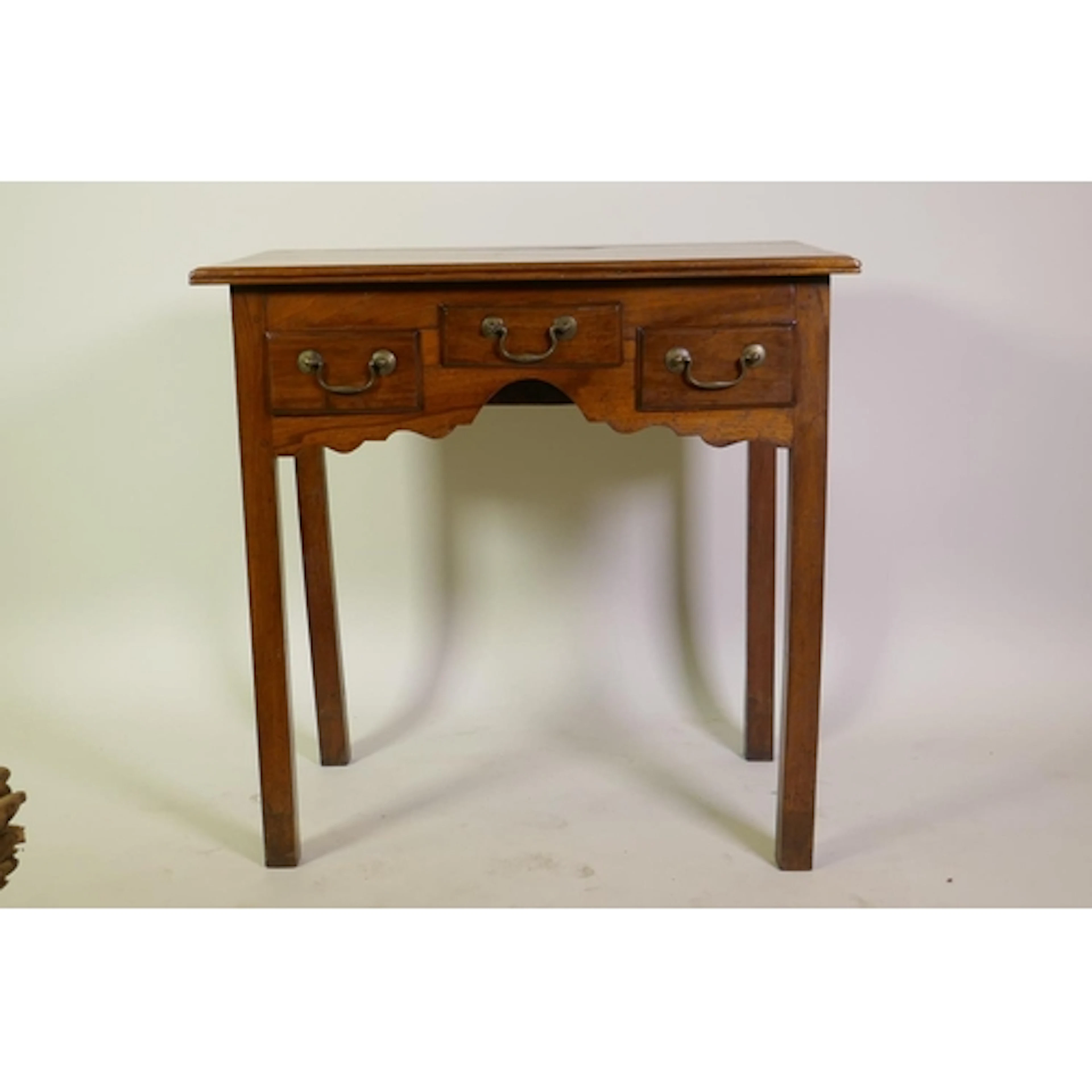 A Georgian walnut lowboy, with reeded edge top over three dr...