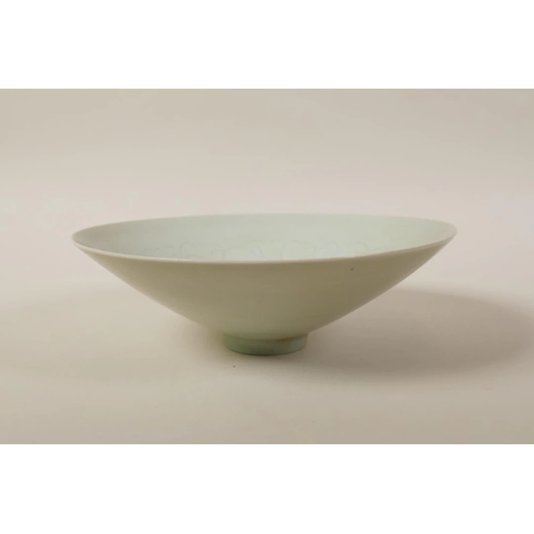 A Chinese celadon glazed porcelain bowl of conical form, wit...