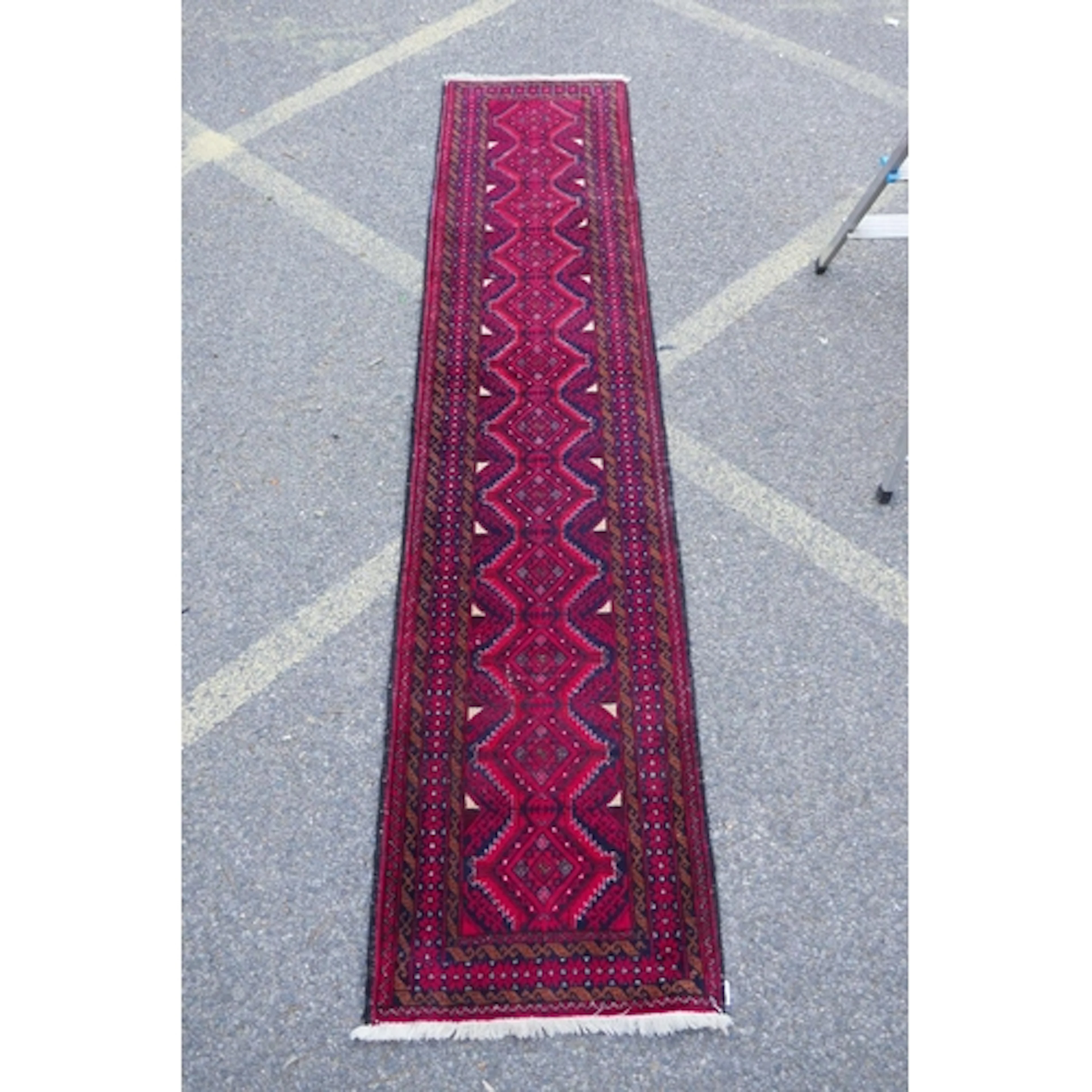 A Middle Eastern hand woven wool runner with geometric desig...