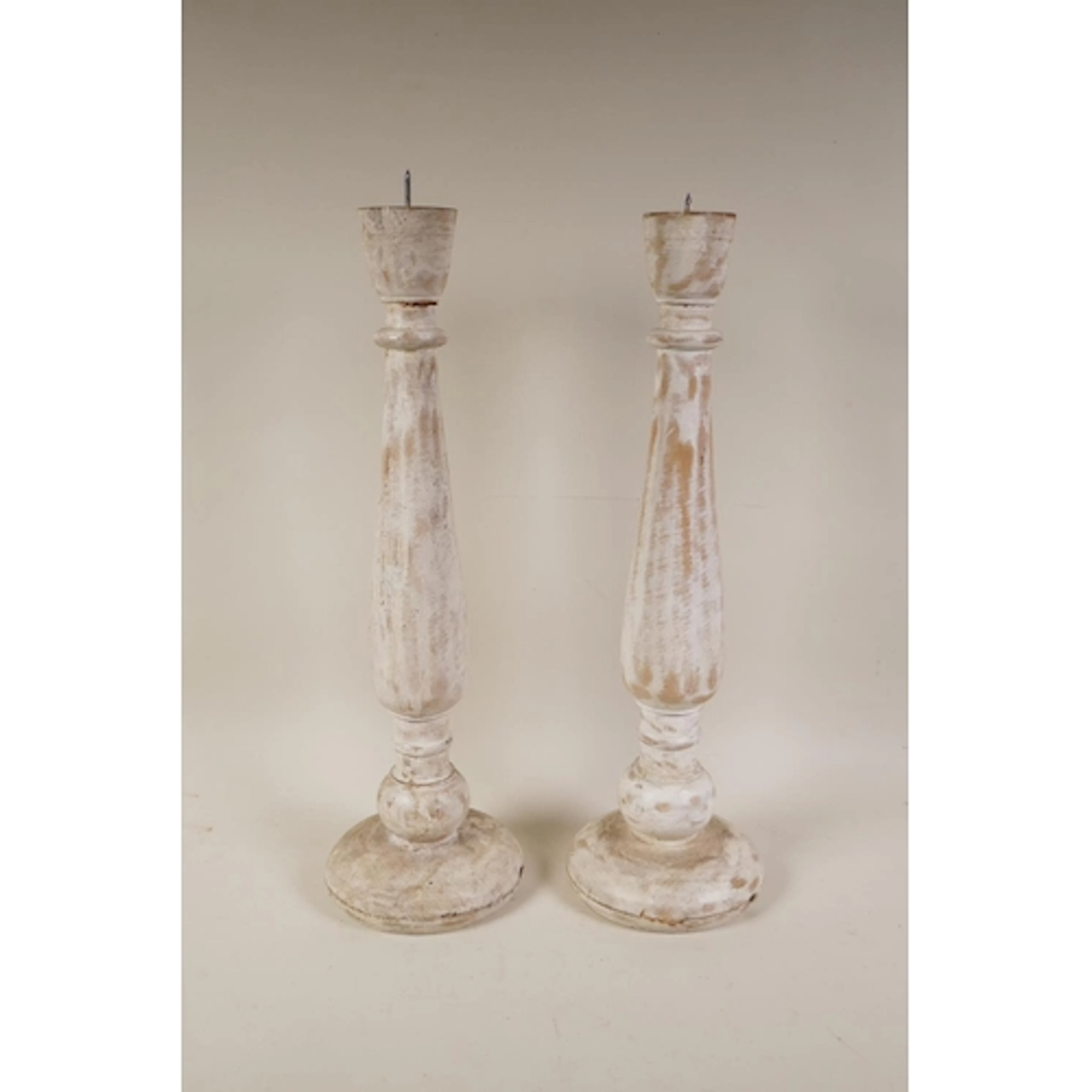 A pair of turned wood, painted and distressed pricket candle...