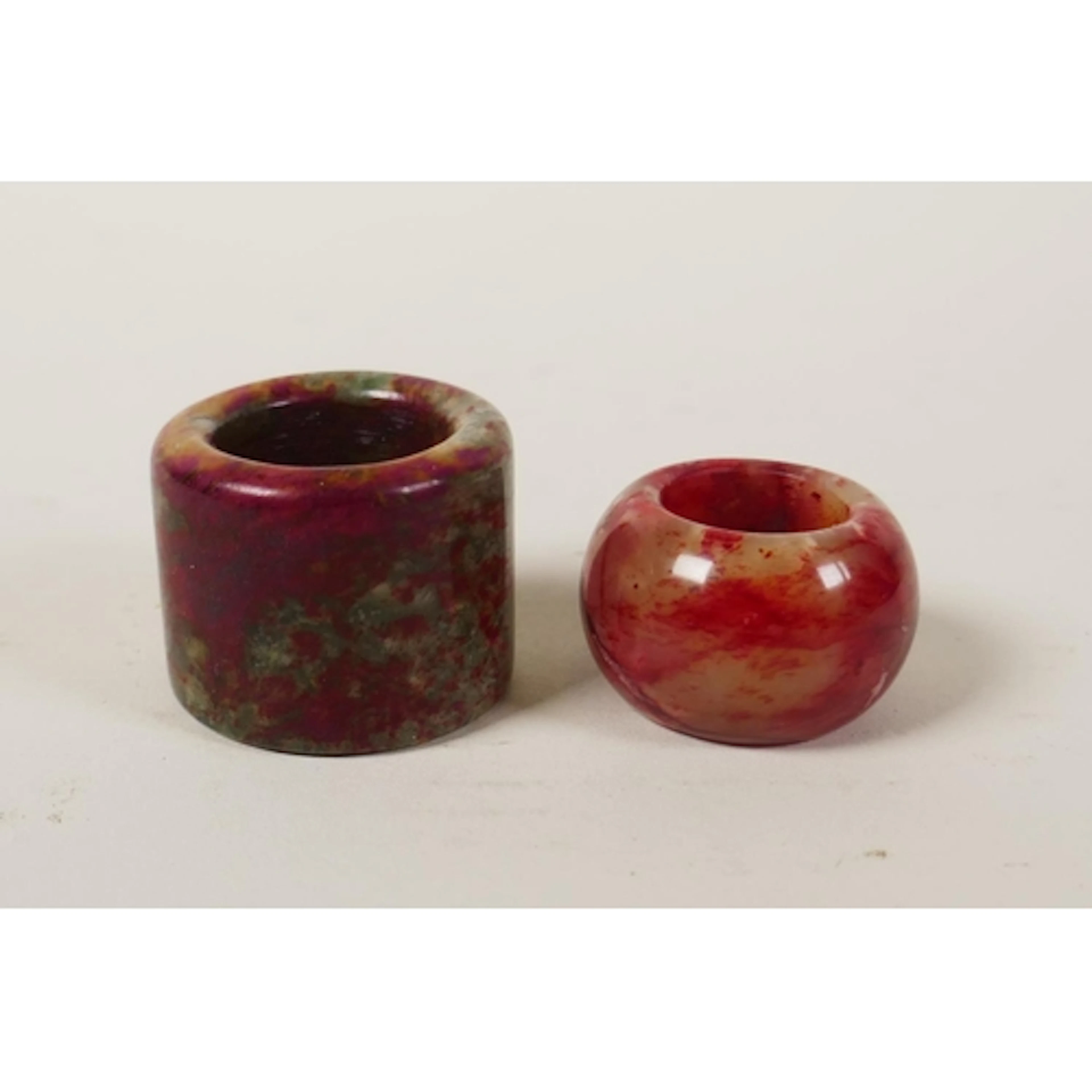 A Chinese mottled red and green hardstone archer's thumb rin...