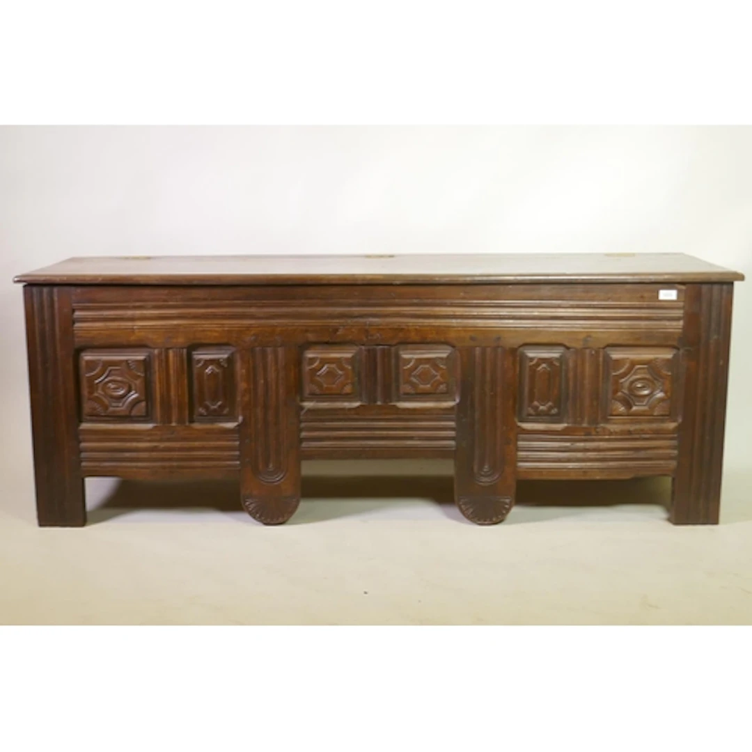 An C18th/C19th French oak coffer with carved panels to front...
