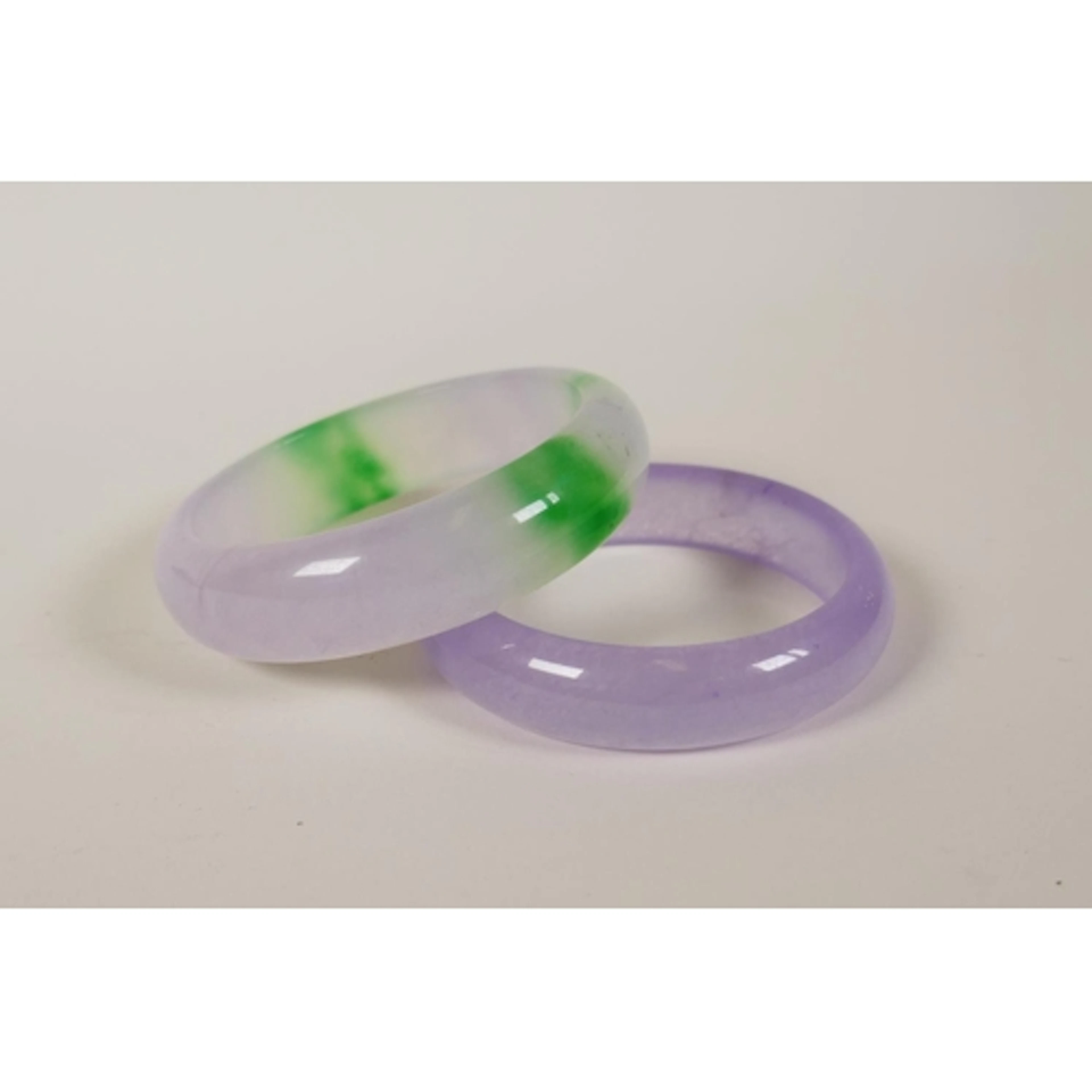 A bi-colour jade/hardstone bangle and another, 8cm diameter ...