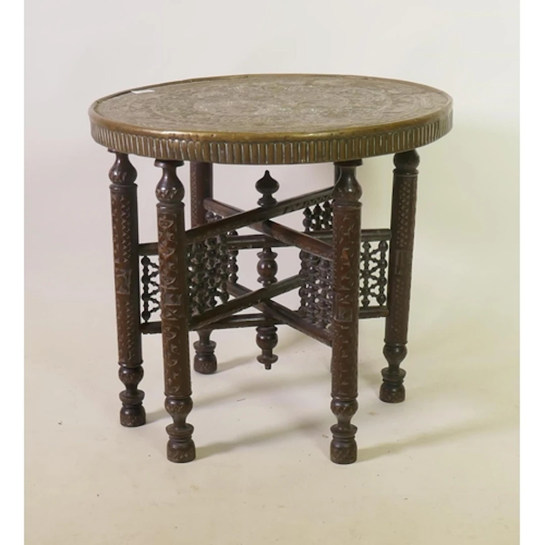 An antique brass top table with repousse decoration of Islam...