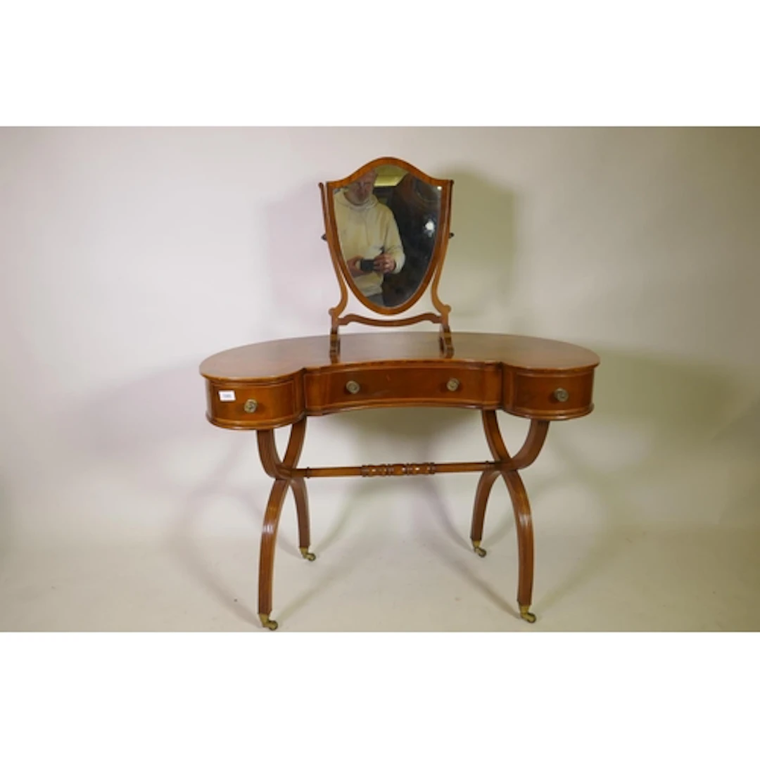 A figured mahogany kidney shaped dressing table of three dra...