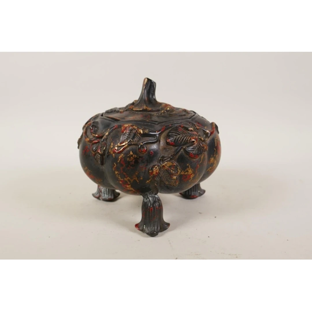 A Chinese gourd shaped bronze censer and cover on tripod sup...