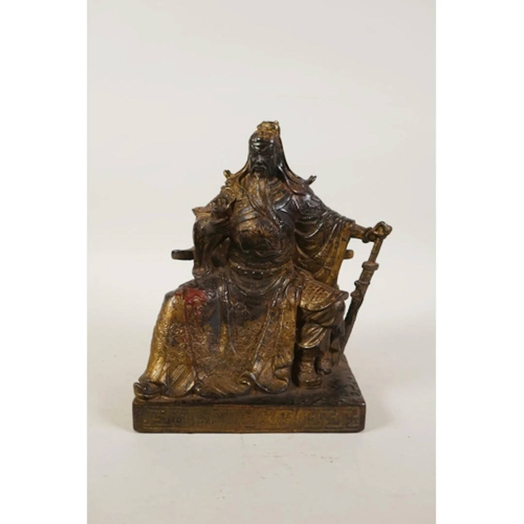 A Chinese gilt bronze figure of Guan Yu seated on a throne, ...