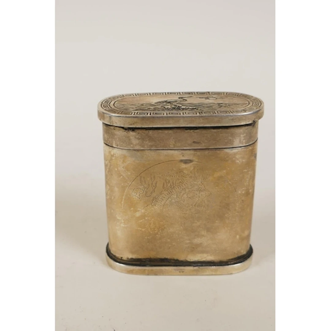 A Chinese white metal tobacco box with engraved dragon and p...