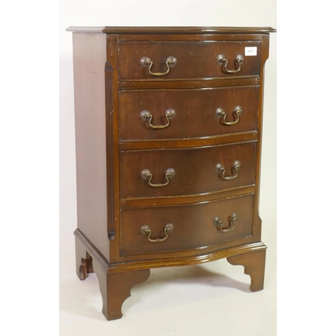 A Georgian style mahogany serpentine shaped chest of four dr...