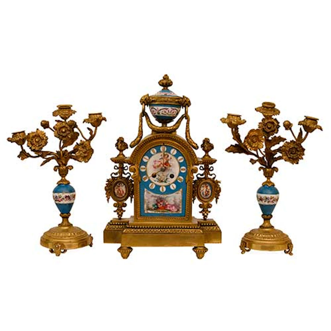 Guarnicin compuesta por reloj y dos candelabros en bronce dorado al