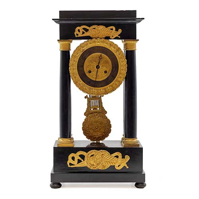 Reloj de columnas en madera ebonizada y aplicaciones en bronce dorado