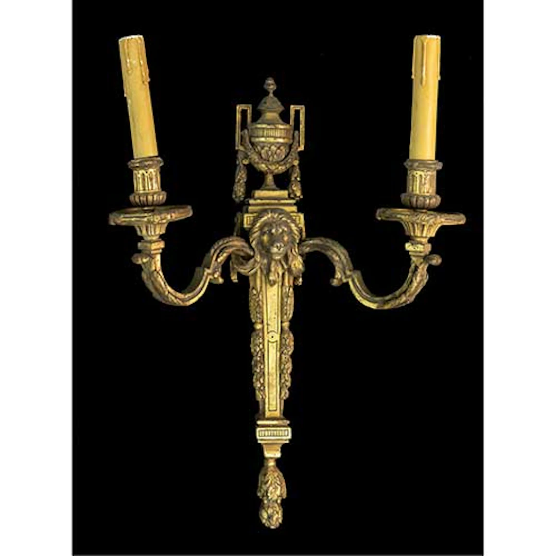 Aplique de pared en bronce modelo Luis XVI con cabeza de len de dos luces.