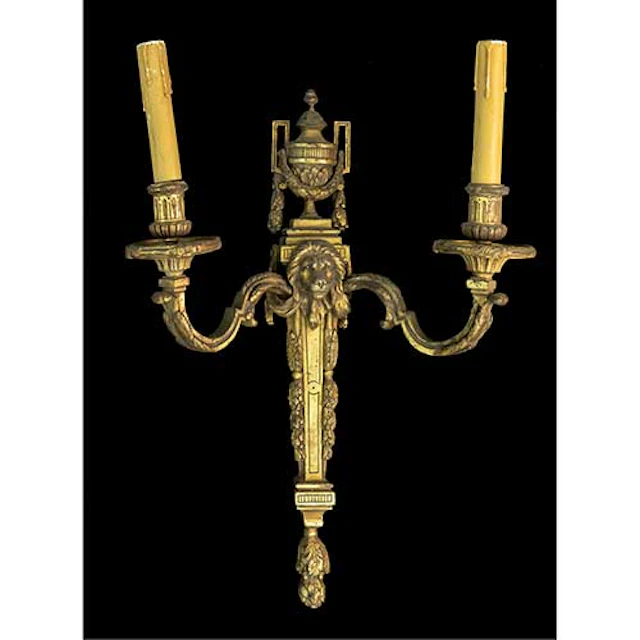 Aplique de pared en bronce modelo Luis XVI con cabeza de len de dos luces.