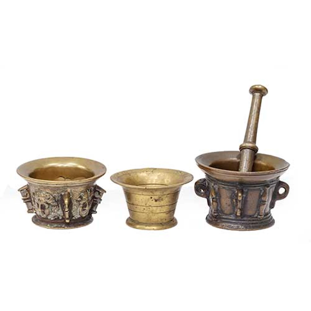 Tres almireces en bronce, uno con mascarones y columnas, otro con