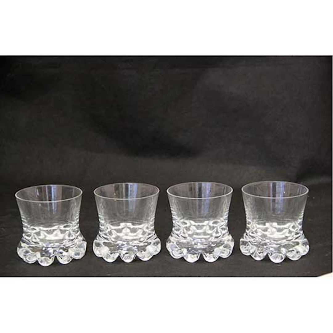 Lote de cuatro vasos bajos para licor en cristal con base alabeada.
