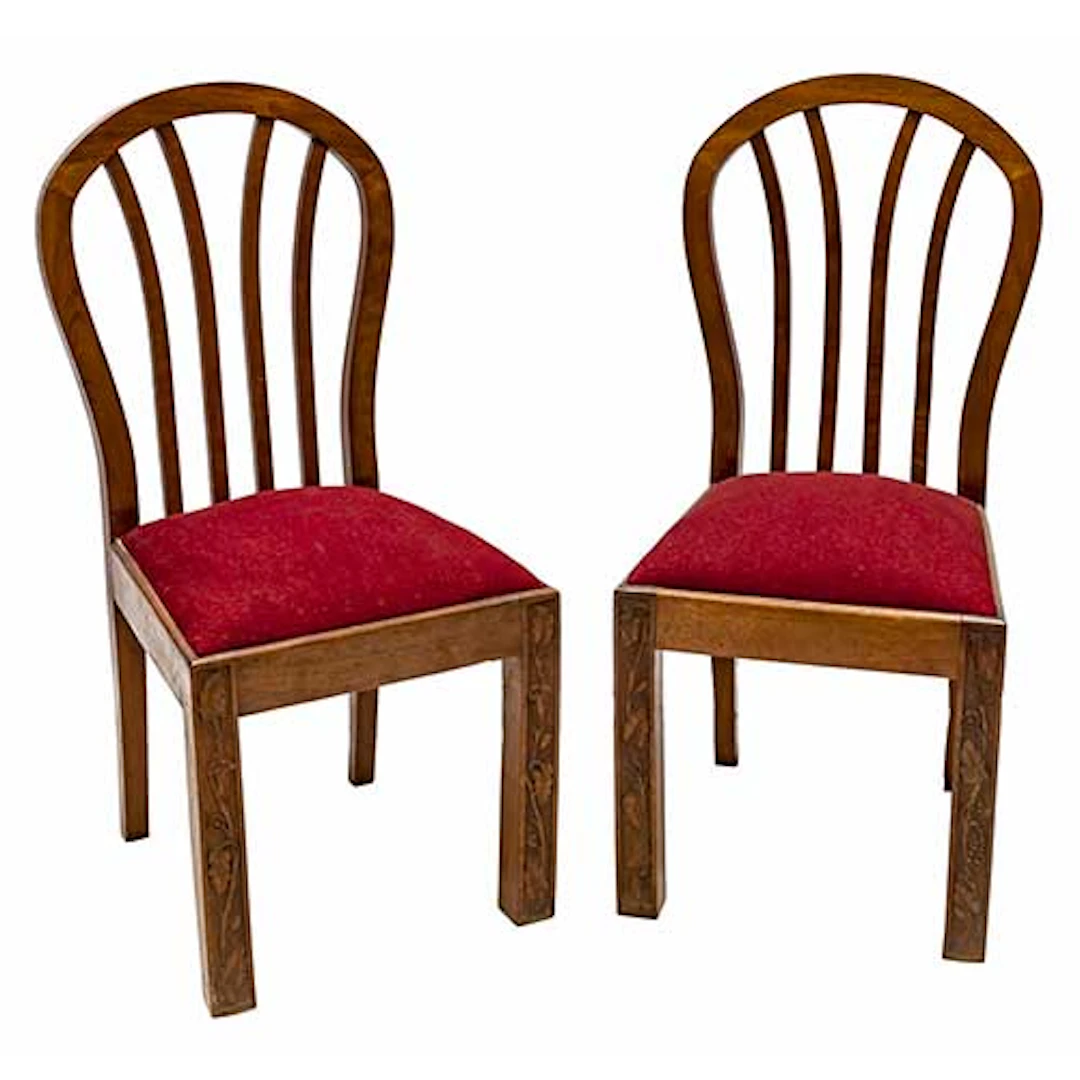 Pareja de sillas en madera con motivos vegetales tallados en las patas.