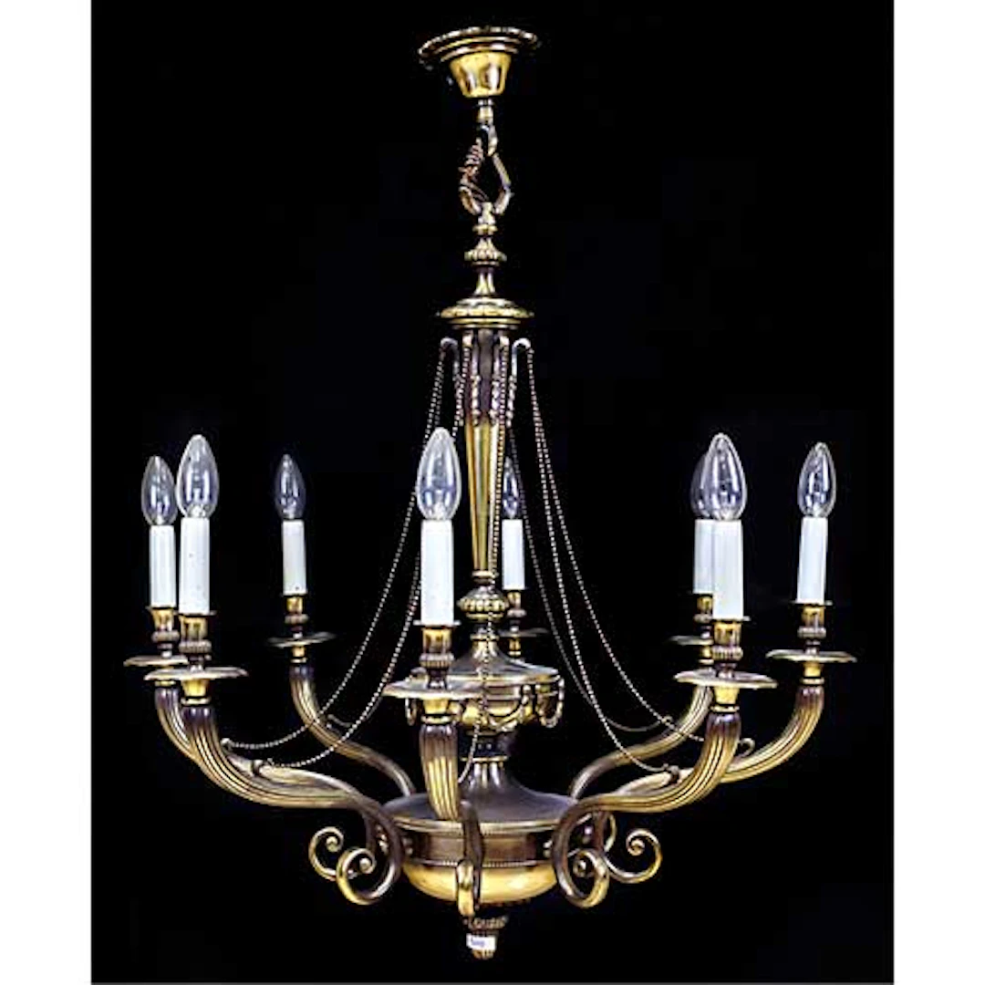 Lmpara de techo con ocho luces en metal dorado, con brazos y fuste estriados.