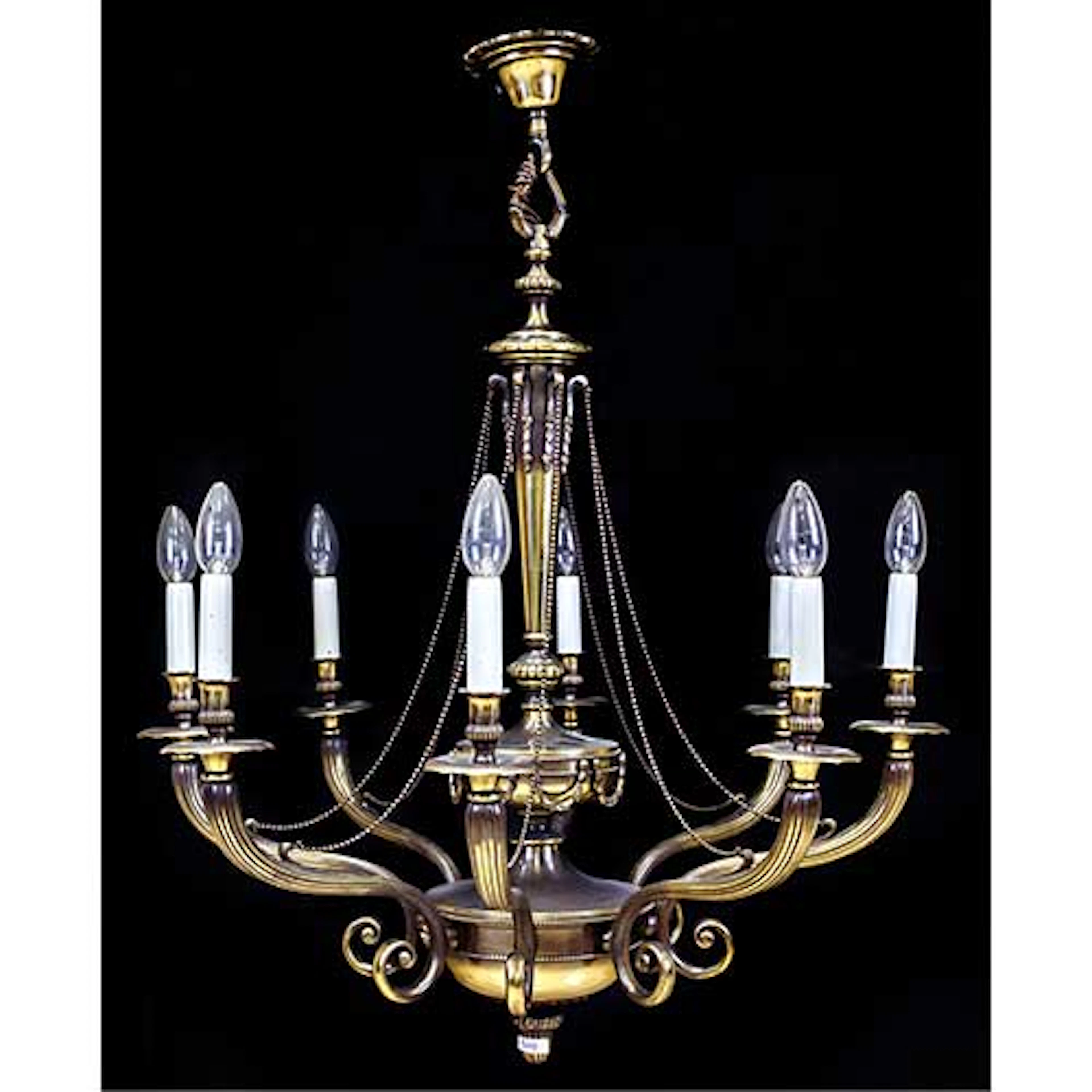 Lmpara de techo con ocho luces en metal dorado, con brazos y fuste estriados.