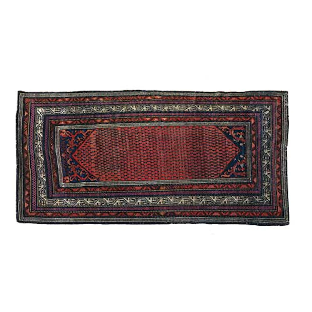 Alfombra persa de pasillo con motivos geomtricos sobre tonalidad roja.