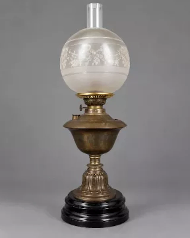Early 20th century oil lamp, brass body over an ebonised ceramic base.