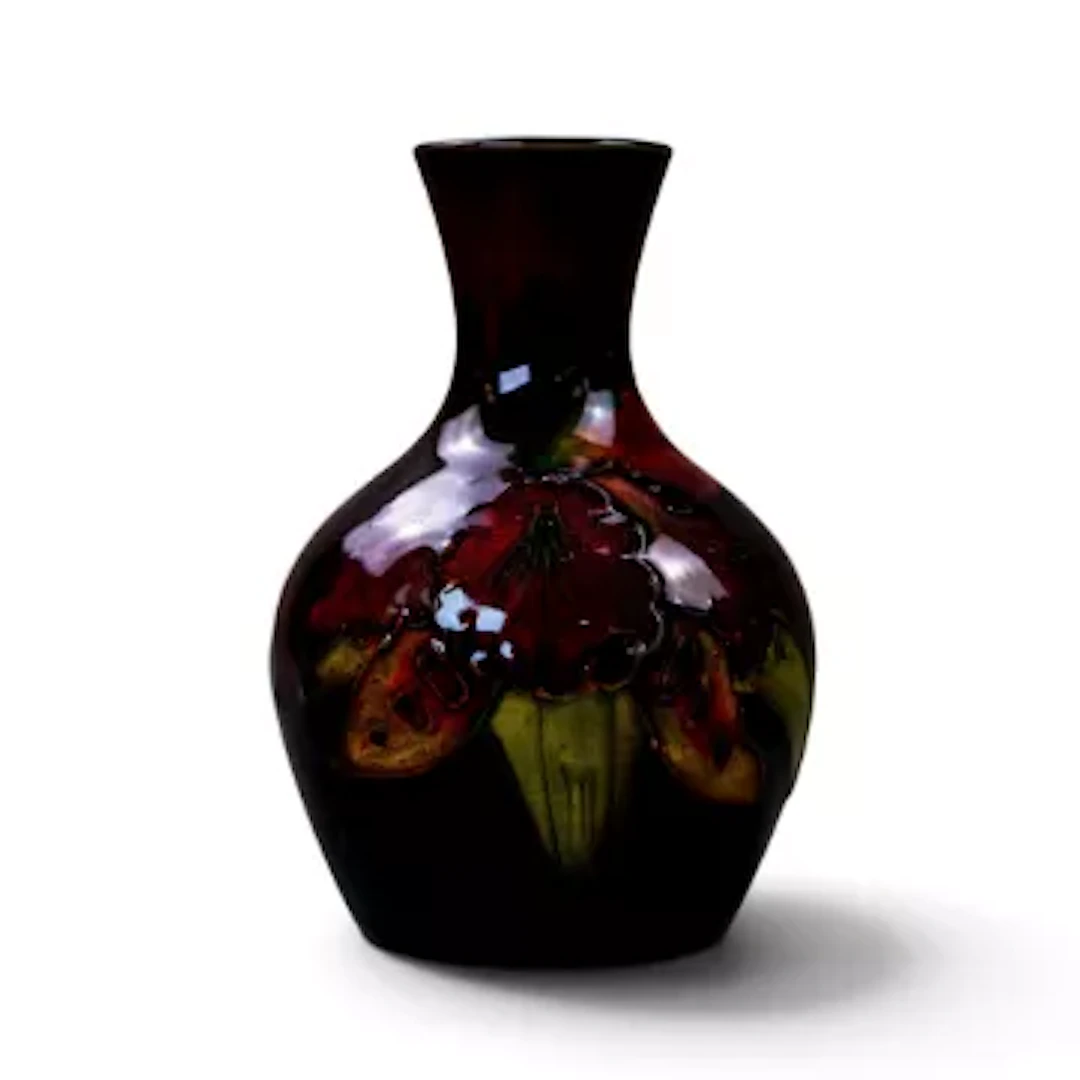 A Moorcroft vase in the Orchid design under a rich flambe glaze by