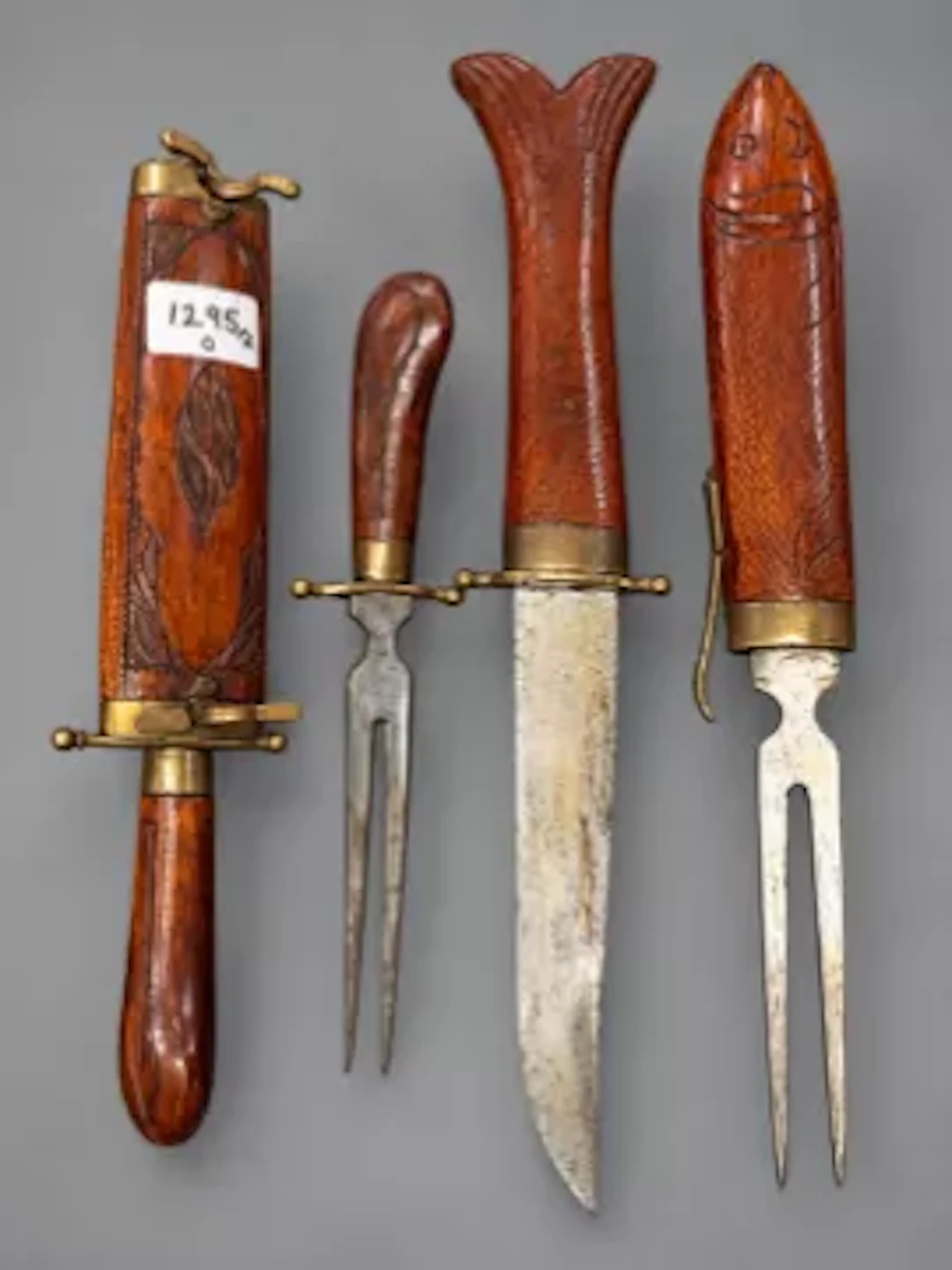 Two Indian hand carved wooden cased carving knife and fork sets (2).